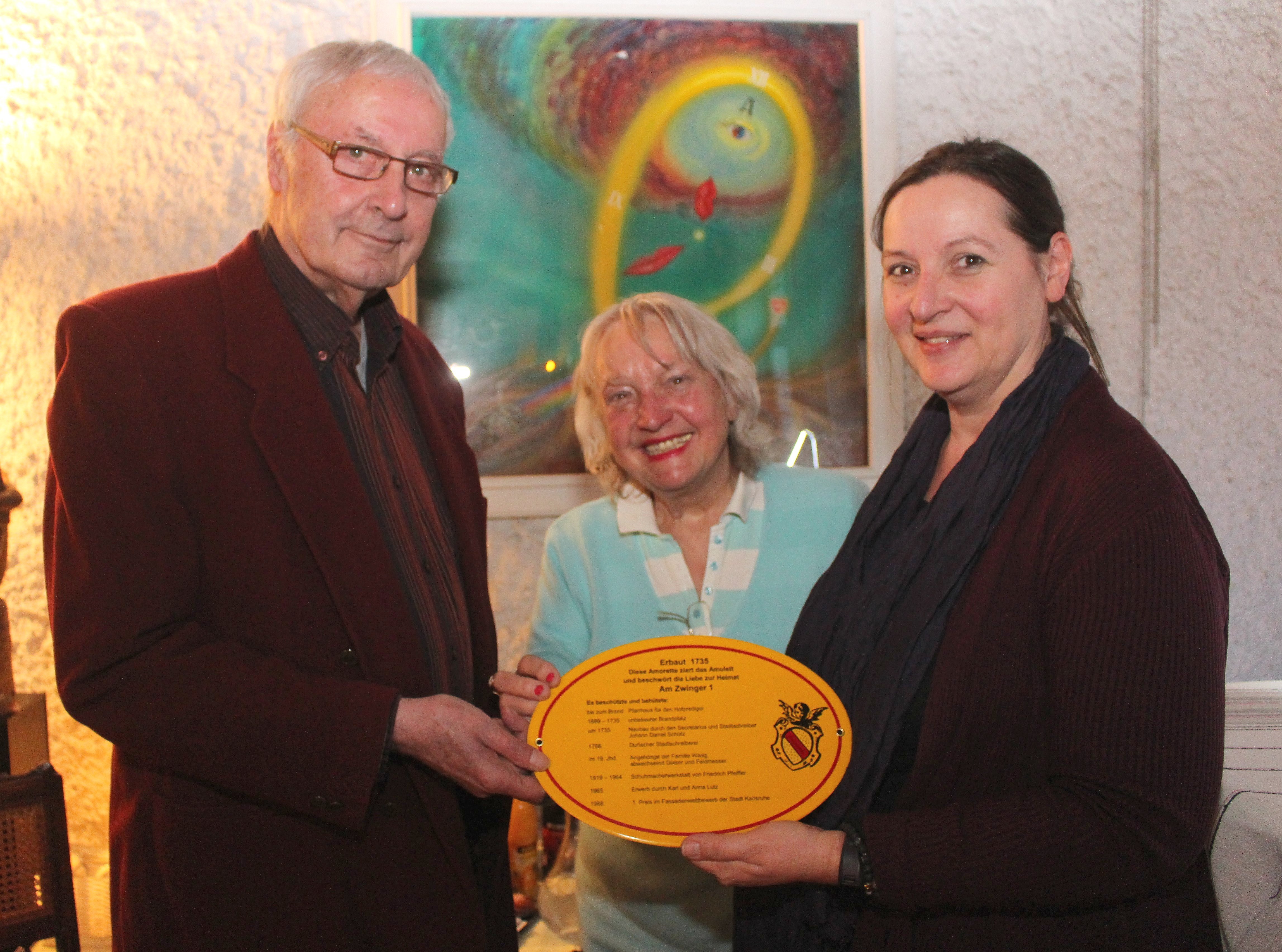 Geschichte wird sichtbar im Durlacher Alltag. Amulett/Schild-Übergabe (v.l.): Wolfgang Schön, Initiatorin Gerda Schneider und Künstlerin Karin Münch