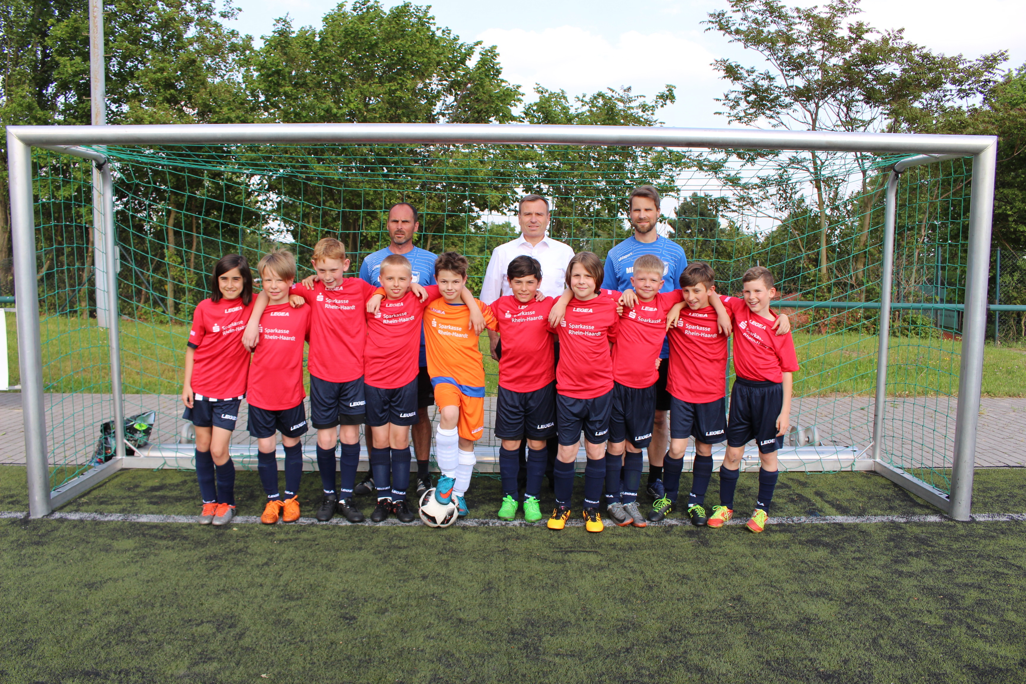 Die E-Jugend des FC 23 Hambach in ihren neuen, von der Sparkasse Rhein-Haardt gesponserten Trikots mit Trainer Erwin Sobieski, Marcus Veth von der Sparkasse Rhein-Haardt und Trainer Marek Pietzonka.