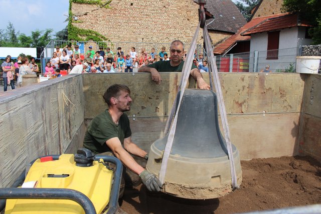 Mit einem Bagger wird die Glocke in die Gießgrube eingelassen. | Foto: Pacher