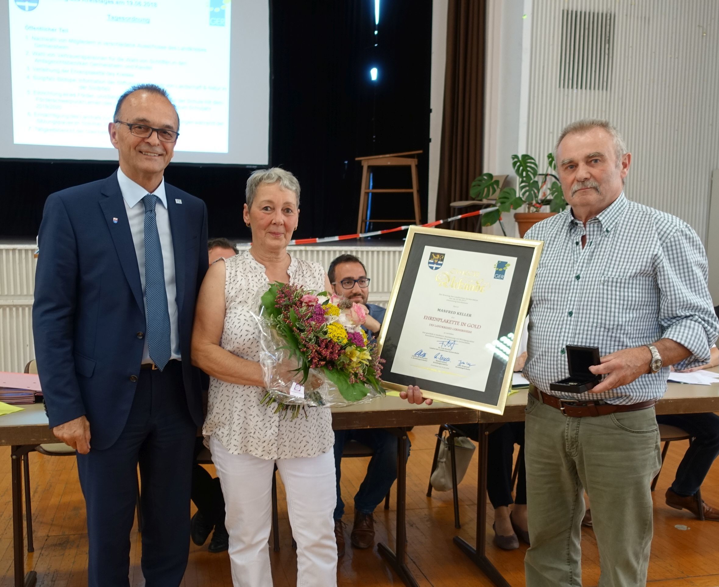 Landrat Dr. Fritz Brechtel (links) hat Manfred Keller (rechts) im Beisein dessen Ehefrau die Ehrenplakette verliehen.