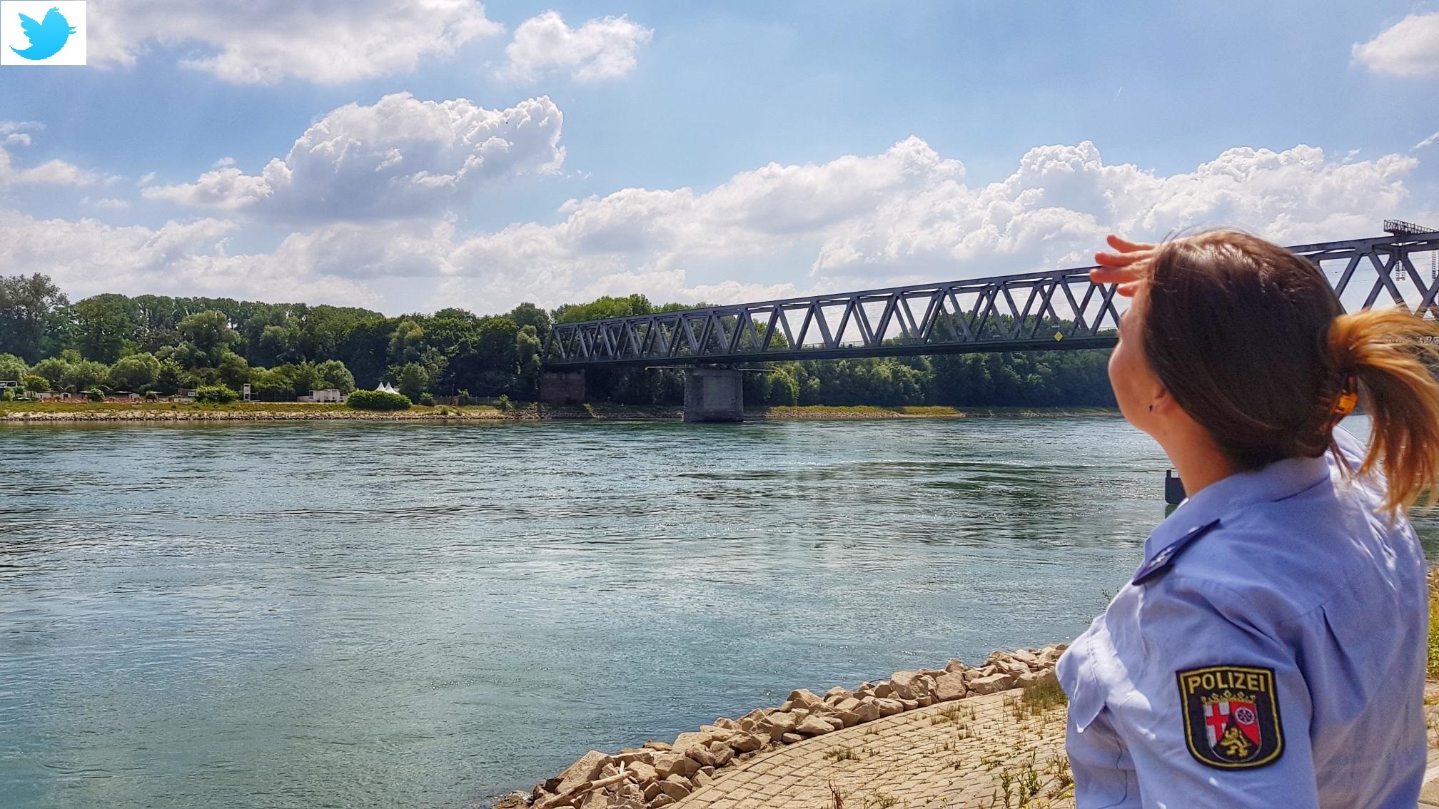 Eine Polizeibeamtin blickt am Rhein in Germersheim der Schwalbe nach.