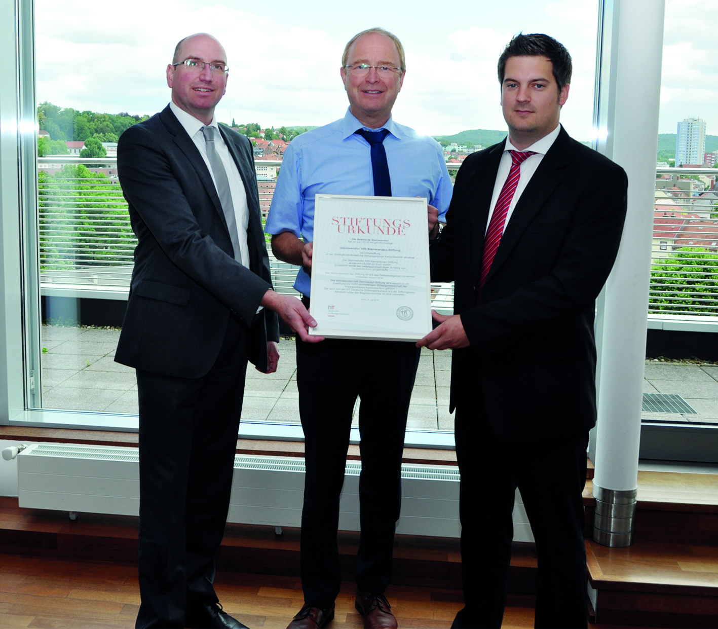 Hartmut Rohden, Vorstandsmitglied der Kreissparkasse Kaiserslautern, Matthias Huber, Ortsbürgermeister von Steinwenden und Patrick Roth, Stiftungsberater der Kreissparkasse (von links) bei der Unterzeichnung der Stiftungsurkunde
