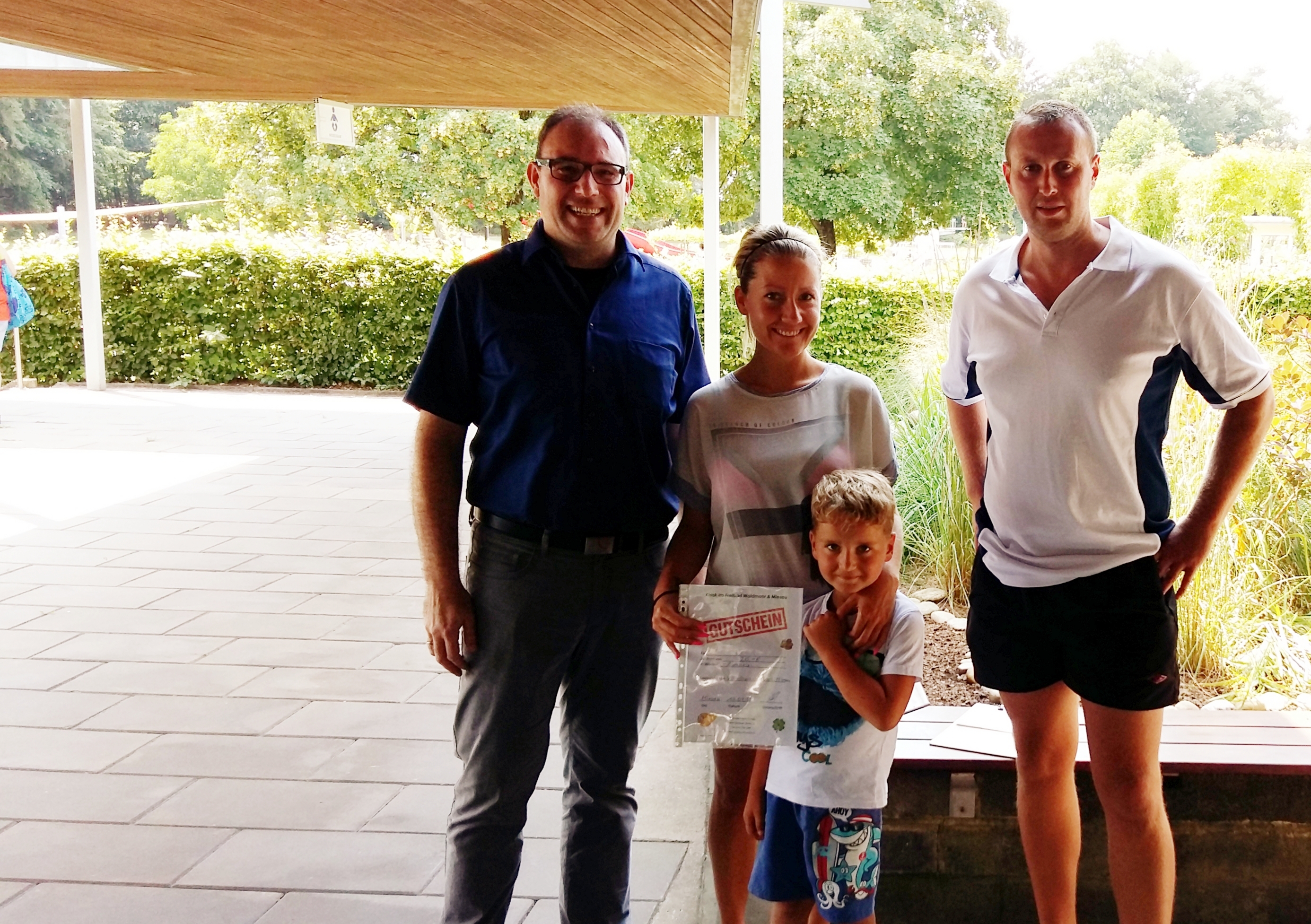 30.000ste Besucher: Familie Wintergerst aus Miesau (Mitte) mit Bürgermeister Erik Emich (links) und Freibadmitarbeiter Igor Makeev (rechts)