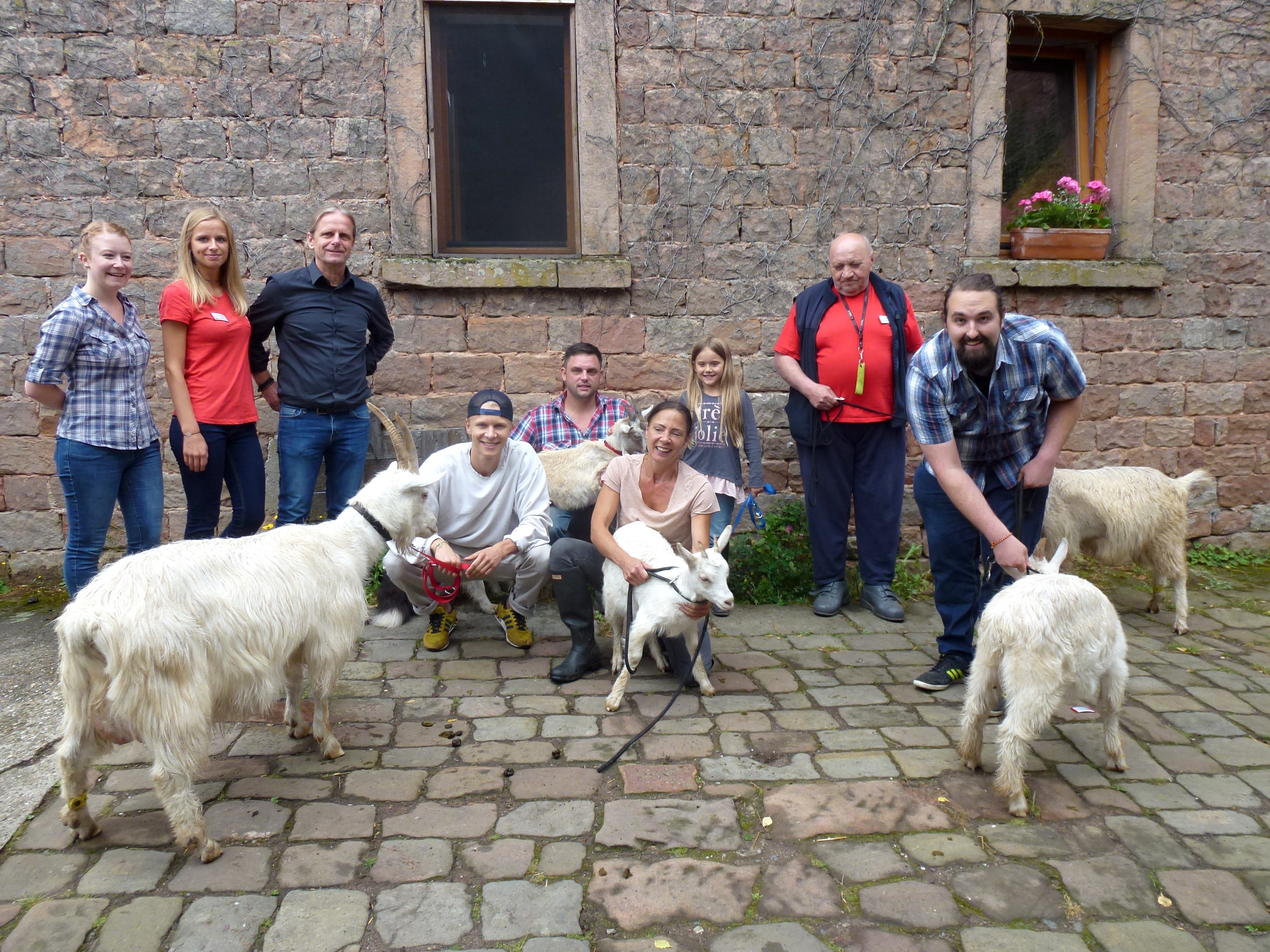 Gruppenfoto nach der Ankunft der neuen Tieren: Die Mitarbeiter vom Wilensteiner Hof und die Spenderin Judith Kern (vierte von rechts) mit den Ziegen und ihrem Nachwuchs