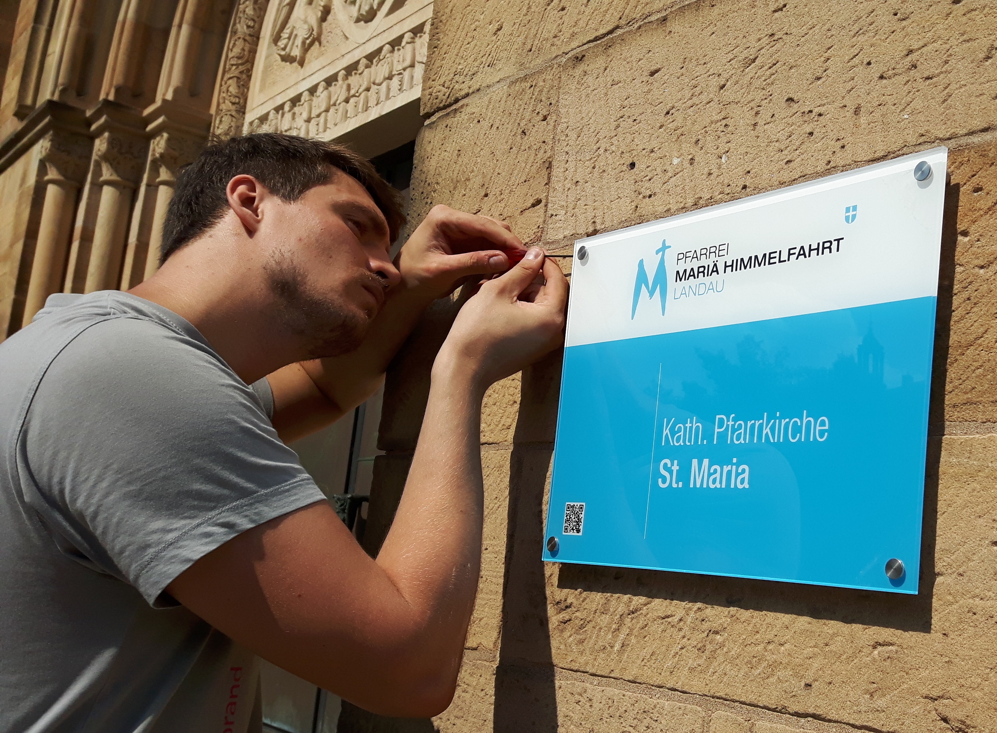 Vadim Hergert, Mitarbeiter der Landauer Firma Schilder-Hannes, bei der Montage der neuen Schilder.