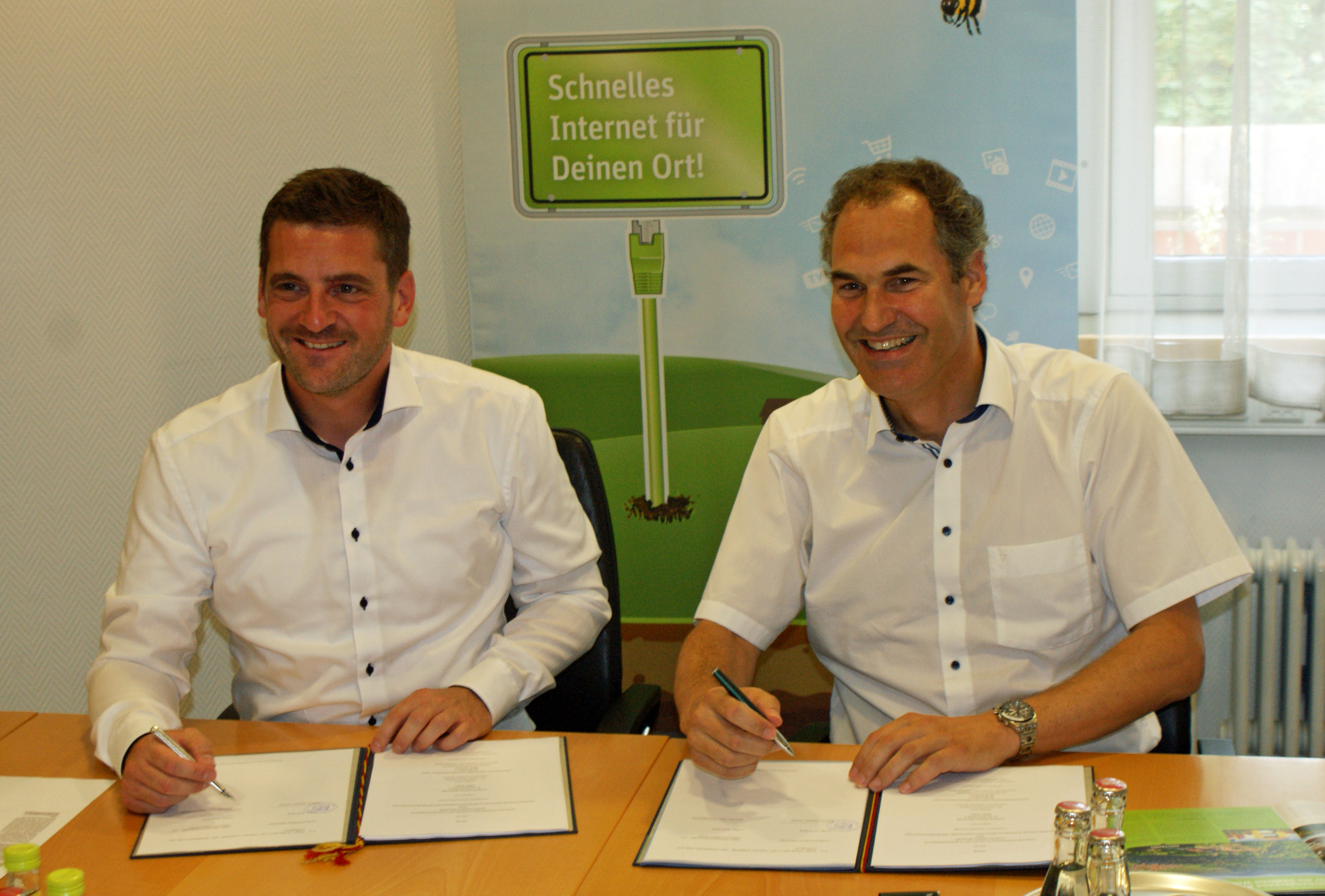 Der Geschäftsführer der Firma inexio, Thorsten Klein (links), und Landrat Dietmar Seefeldt bei der Vertragsunterzeichnung im Kreishaus.