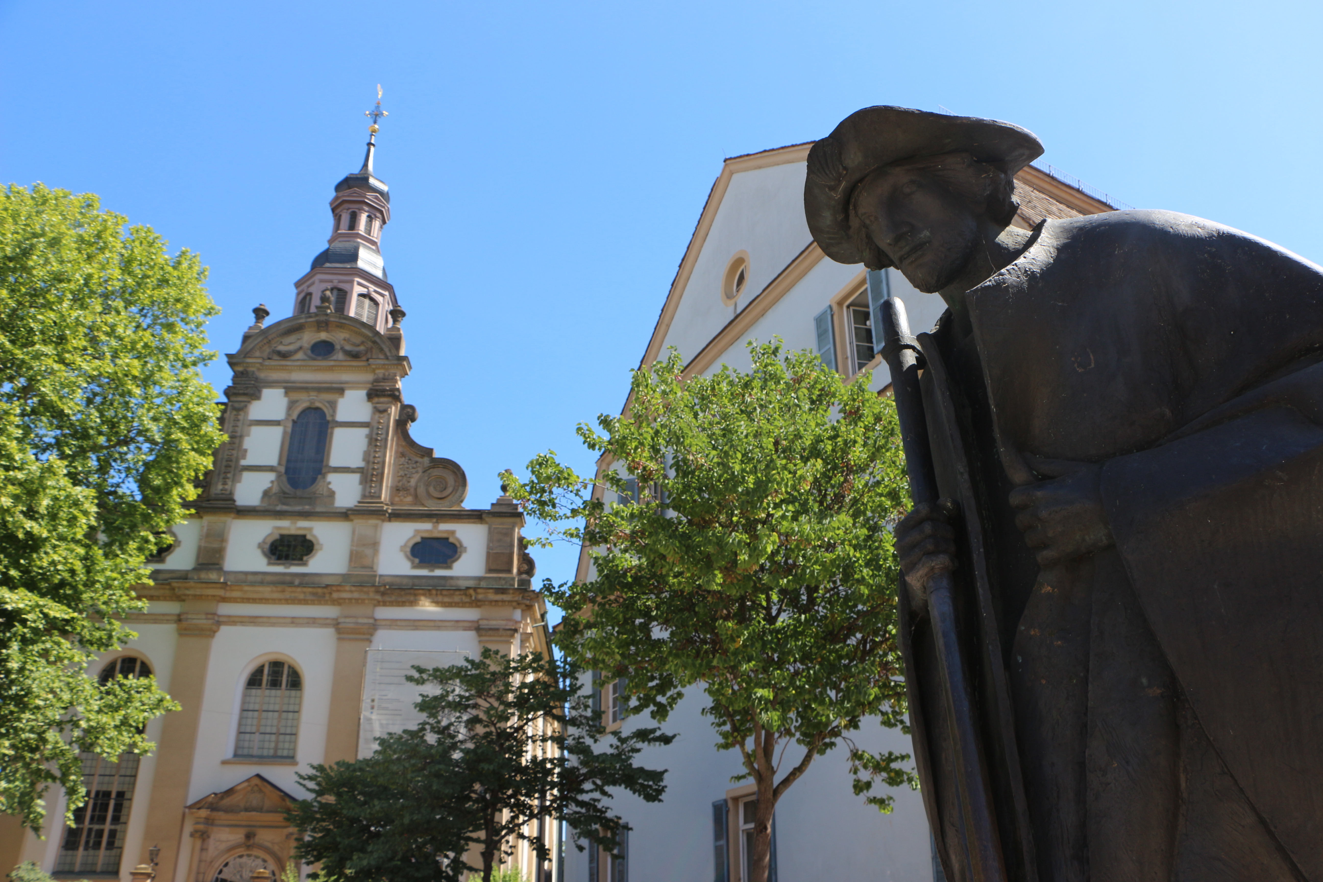 Der Pilger und die Dreifaltigkeitskirche, die noch bis Oktober saniert wird.