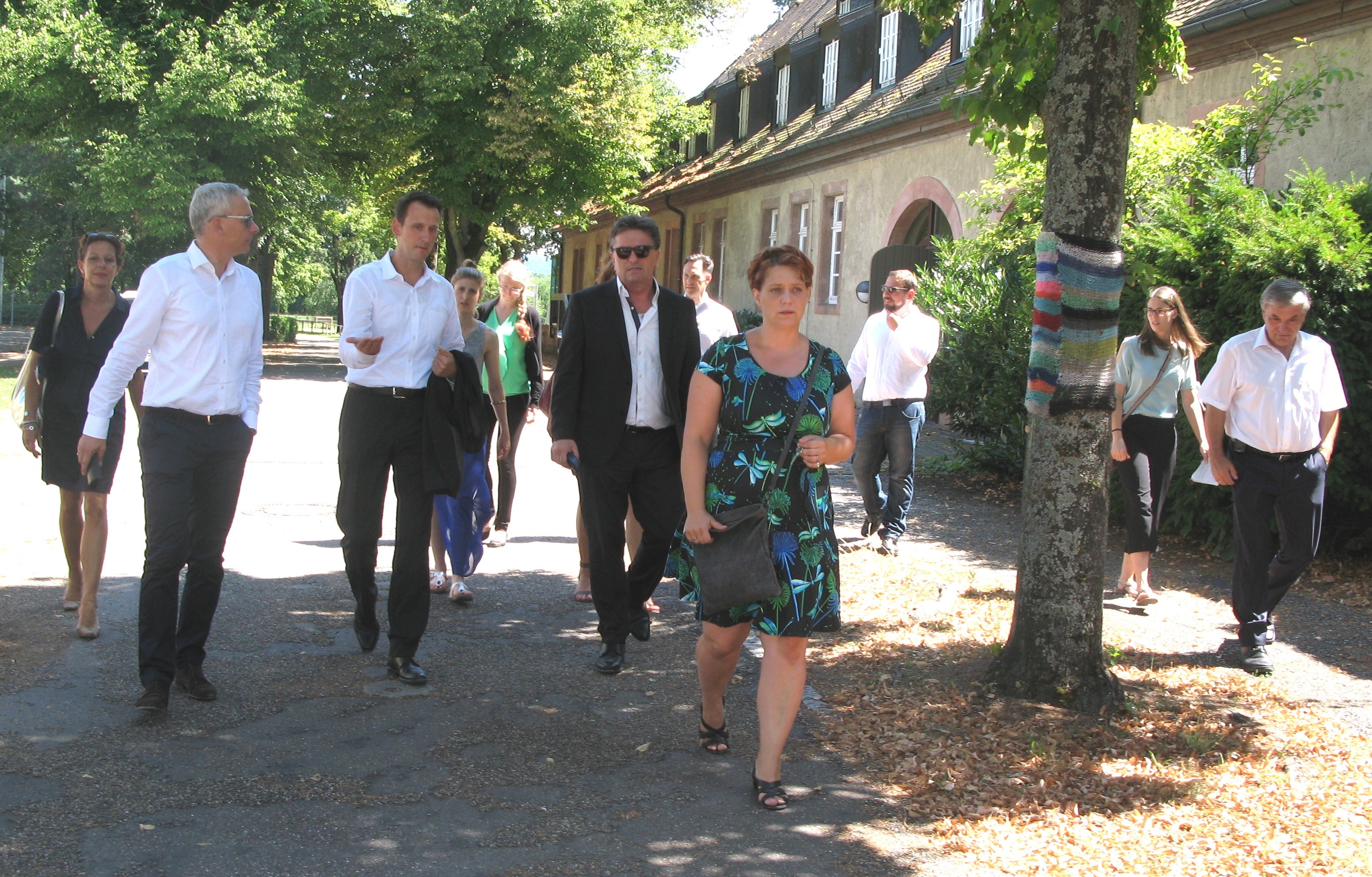 2. Reihe v.l.n.r.): Landrat Dr. Christoph Schnaudigel und Geschäftsführer Jens Brandt beim Rundgang mit Sozialminister Manne Lucha in der Jugendeinrichtung Schloss Stutensee. Bereichsleiterin Sabine Haid (vorne) führte u.a. durch das im Hintergrund zu sehende Heinrich-Wetzlar-Haus. Bürgermeister Edgar Geißler (rechts) vertrat die Stadt Stutensee, die einen guten Kontakt zur Einrichtung pflegt.
