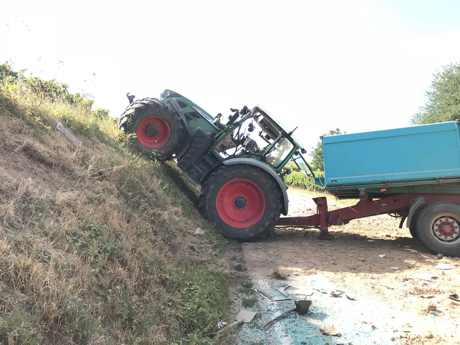 Der Traktor kam auf einer Böschung quer zur Fahrbahn zum Stehen. Die Deichsel des Anhängers setzte hierbei auf der Fahrbahn auf und beschädigte diese erheblich.