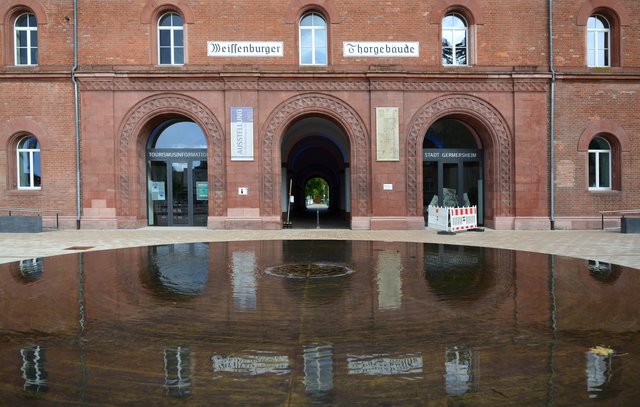 Das Ludwigstor spiegelt sich im Octroi-Brunnen