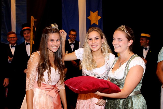 Lena Franz (Mitte) setzt im Beisein der Pfälzischen Weinprinzessin Alisa Weber der neuen Weinprinzessin der Verbandsgemeinde Deidesheim Tamara Fränzl die Krone auf's Haupt.