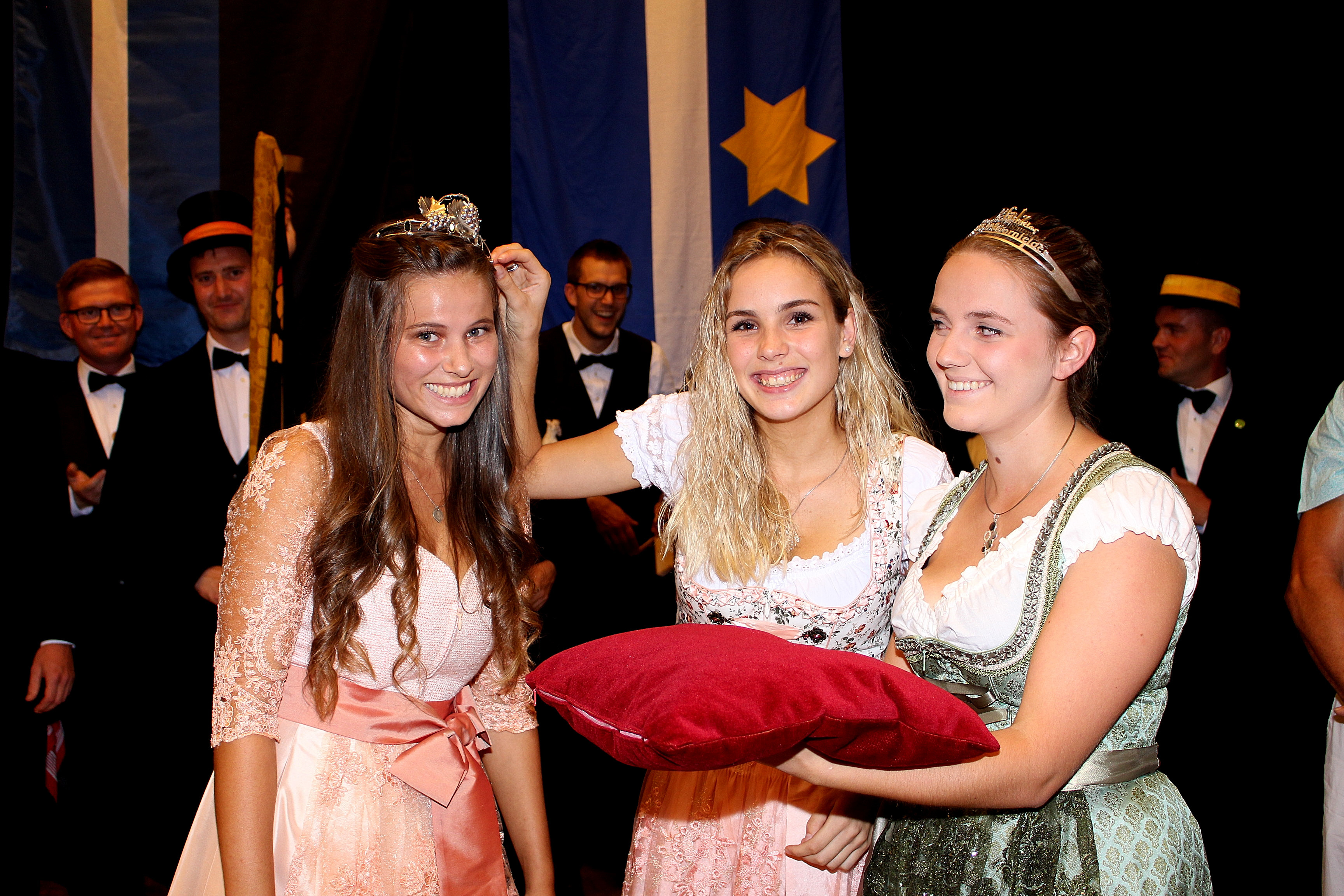 Lena Franz (Mitte) setzt im Beisein der Pfälzischen Weinprinzessin Alisa Weber der neuen Weinprinzessin der Verbandsgemeinde Deidesheim Tamara Fränzl die Krone auf's Haupt.