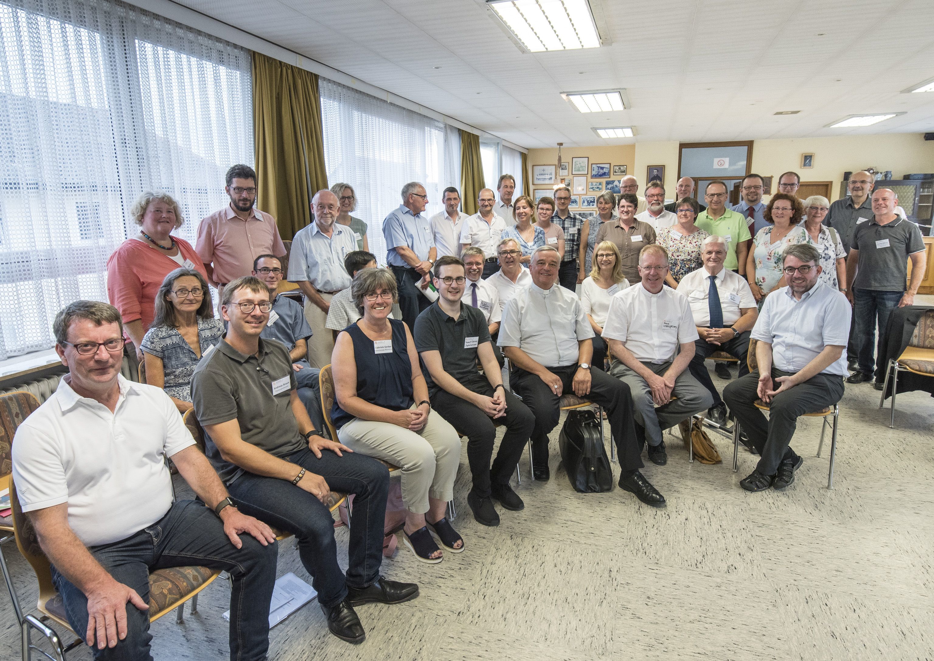 Pfarrer Steffen Kühn, Domkapitular Franz Vogelgesang und Bischof Wiesemann (vorne von rechts) mit den Mitgliedern des Pfarrei- und Verwaltungsrates der Pfarrei im Pirmin-Diehl-Haus in Hochspeyer