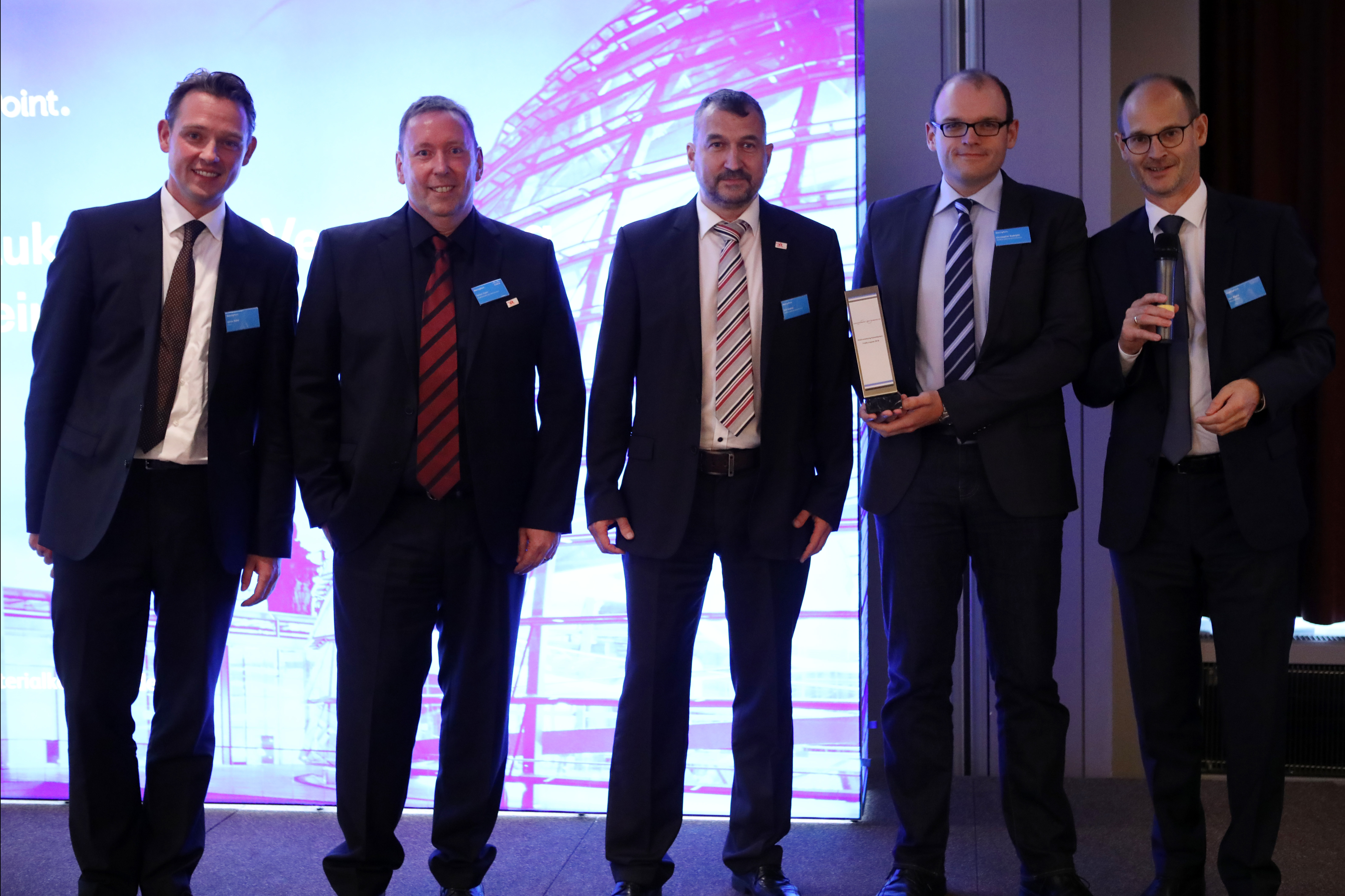Die drei Mitglieder der Stabsstelle Zentralcontrolling, Rainer Kadel (2.v.l.), Dirk Andres (3.v.l.) und Christopher Rudolphi (4.v.l.), mit dem Publikumspreis. Als Vertreter der Ausrichter links Jonas Rahe, Client Executive bei Cisco, rechts Jon Abele von BearingPoint FOTO: Konstantin Gastmann / BearingPoint