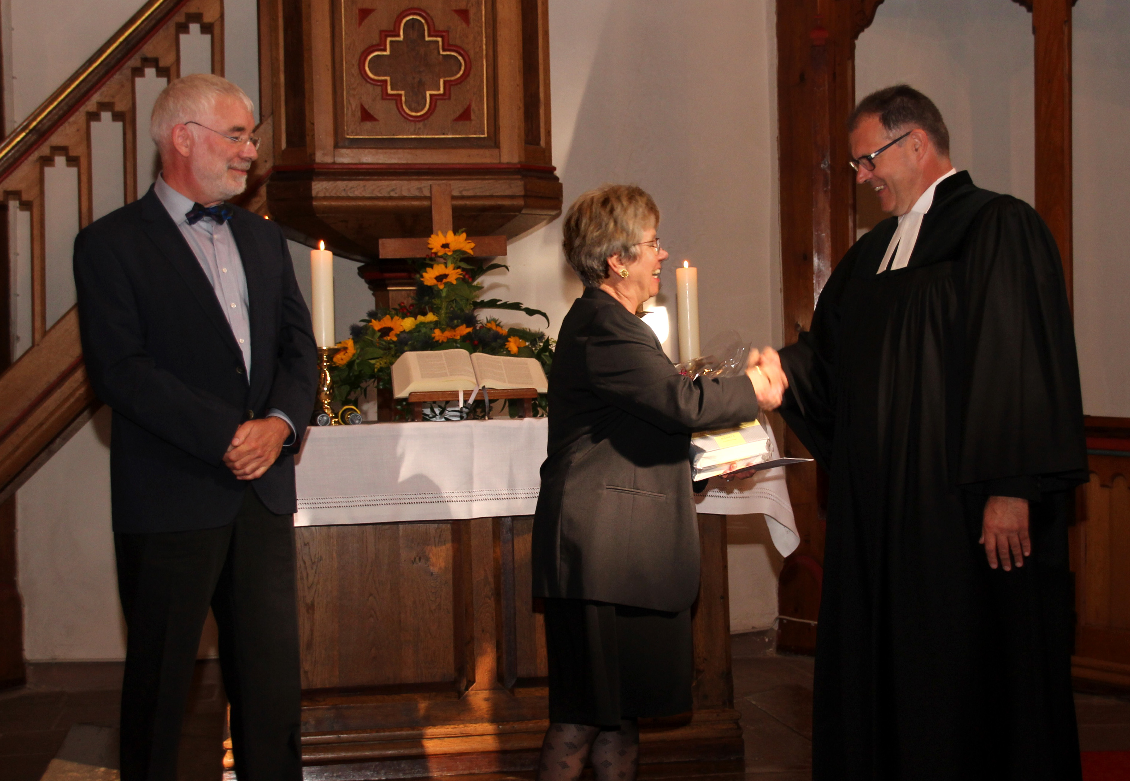 Die beiden Presbyter Dieter Rauland und Doris Sieg gatulieren Pfarrer Bernhard Schäfer zu seinem Priesterjubiläum Foto: Kries