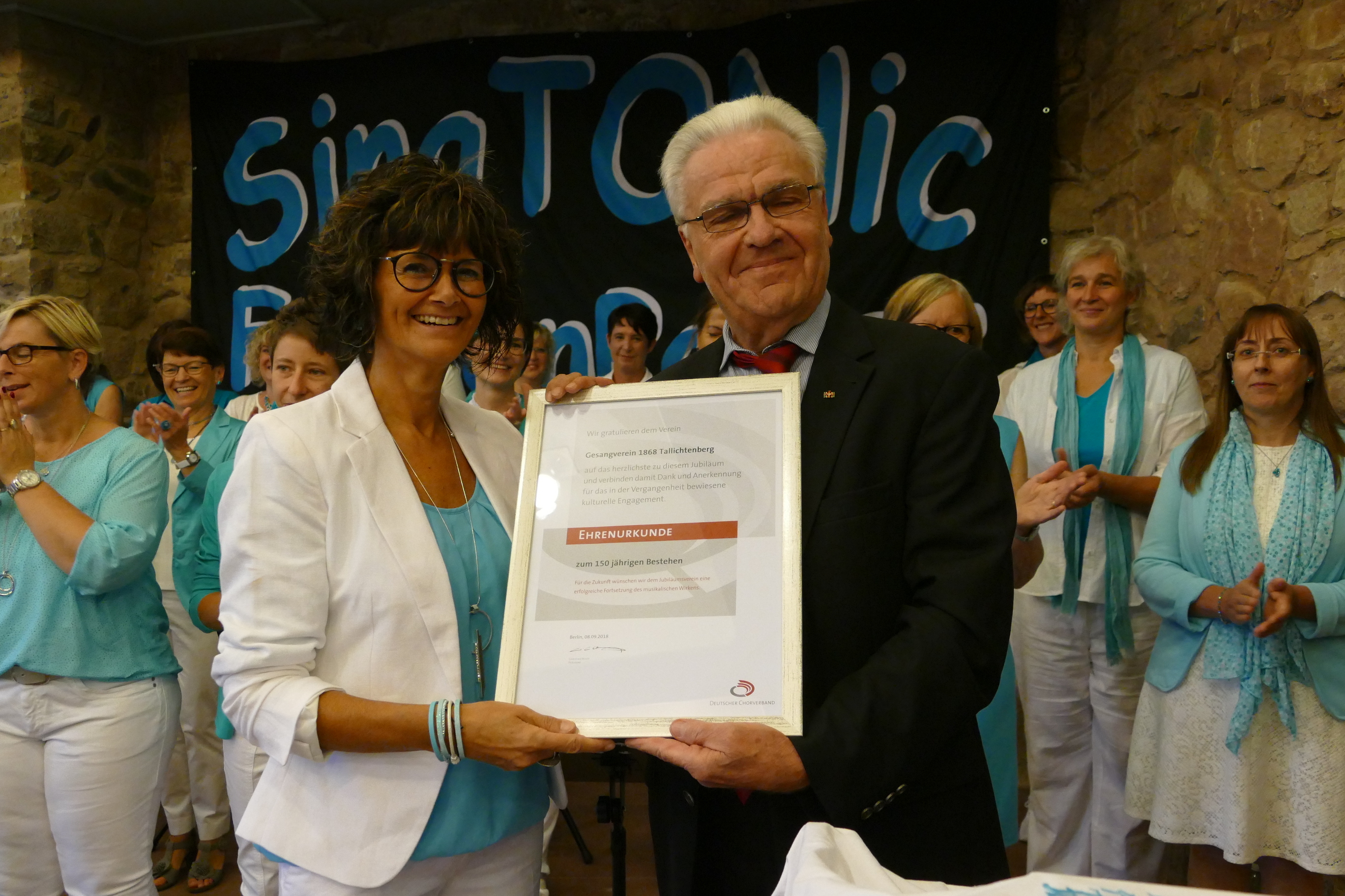 Der Präsident des Chorverbandes der Pfalz, Hartmut Doppler überreichte der Vorsitzenden Karin Jung die Urkunde zum Jubiläum. Foto: Horst Cloß