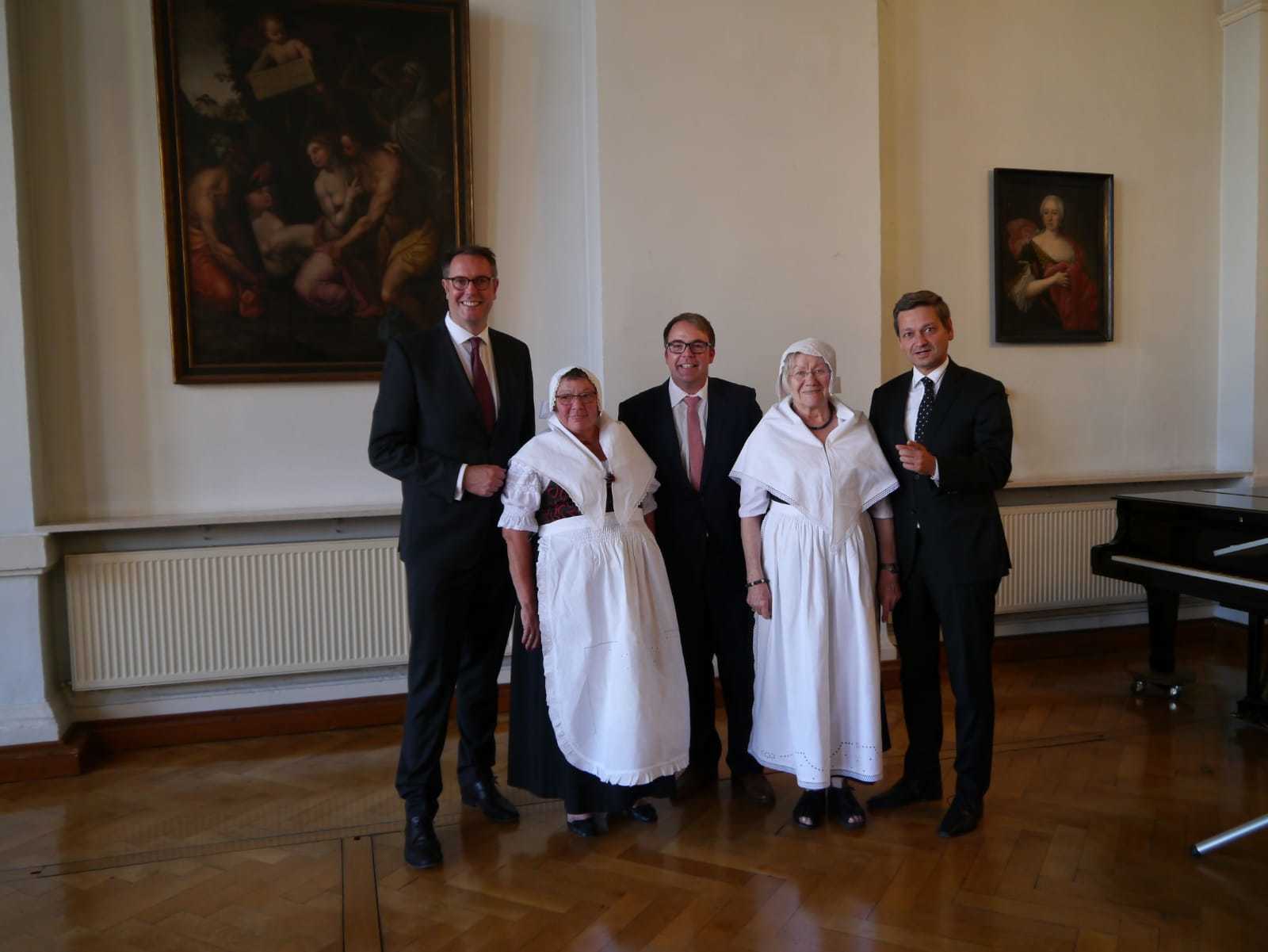 Würdiger Rahmen beim Tag der Heimat (von links): SPD-Fraktionsvorsitzender Alexander Schweitzer, BdV- Landesvorsitzender Tobias Meyer und CDU-Fraktionsvorsitzender Christian Baldauf mit zwei Vertreterinnen des BdV Germersheim in schlesischer Tracht aus dem Riesengebirge.