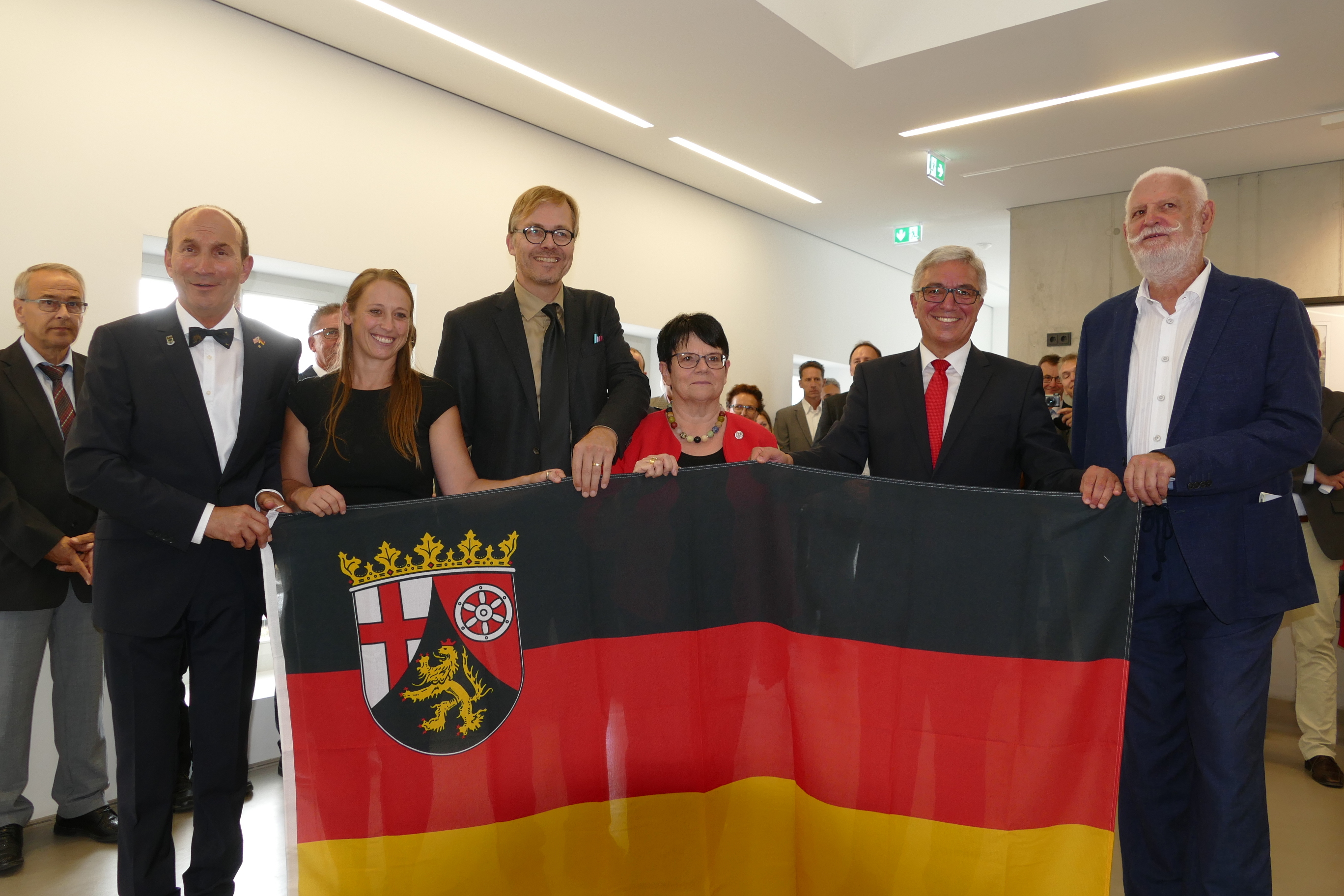 Innenminister roger Lewentz (2.v.r.) übergibt an Stadtbürgermeister Günter Jung (li.) und die Museums-Engel Jeanette Böhm, Architekt Marcus Hille, Ingrid Schwerdtner und Dr., Ulrich Schmidt als Dank eine Fahne mit dem Landeswappen. Fotos: Horst Cloß