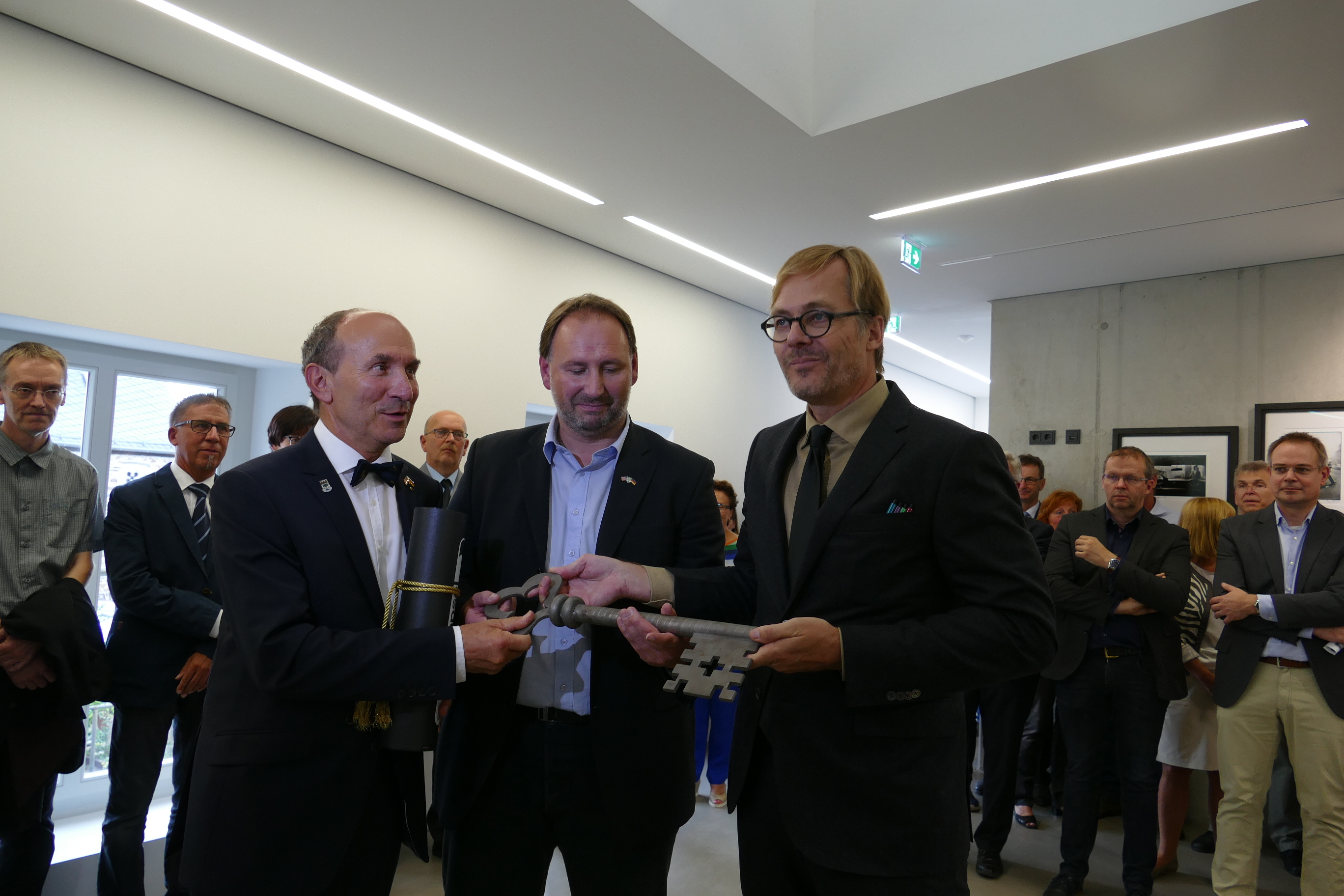 Architekt Markus Hille überreicht den symbolischen Schlüssel an Stadtbürgermeister Günter Jung und den Beigeordneten Christian Flohr.