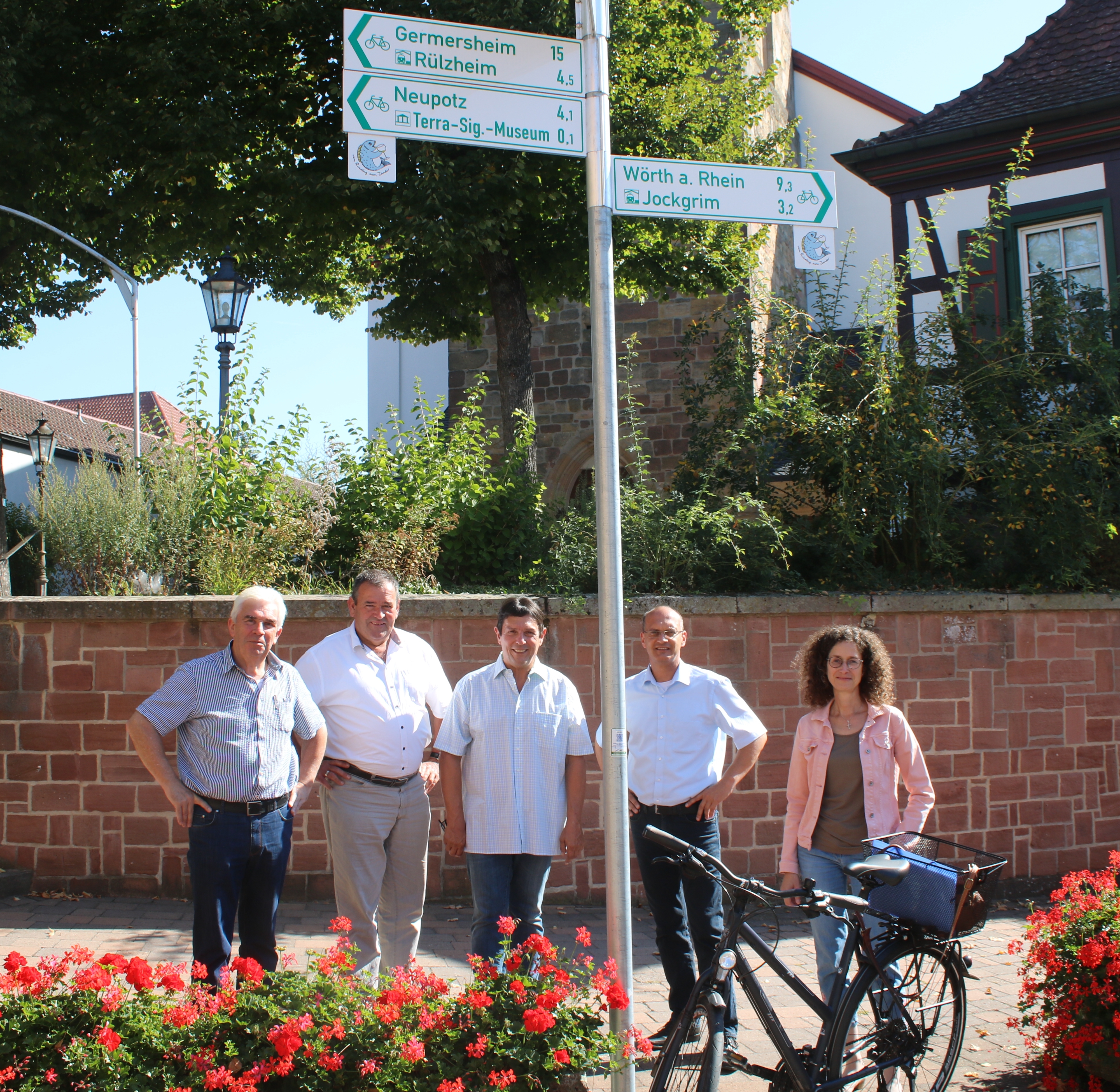 Einer der 86 Schilderstandorte im Radwegenetz der Verbandsgemeinde Jockgrim befindet sich in der Nähe der Katholischen Kirche St. Michael in Rheinzabern. v.l.n.r.: Gerhard Beil (Ortsbürgermeister Rheinzabern), Roland Bellaire (Ortsbürgermeister Neupotz), Karlheinz Henigin (Ortsbürgermeister Hatzenbühl), Bürgermeister Karl Dieter Wünstel, Sabine Baumann (Ortsbürgermeisterin Jockgrim)
