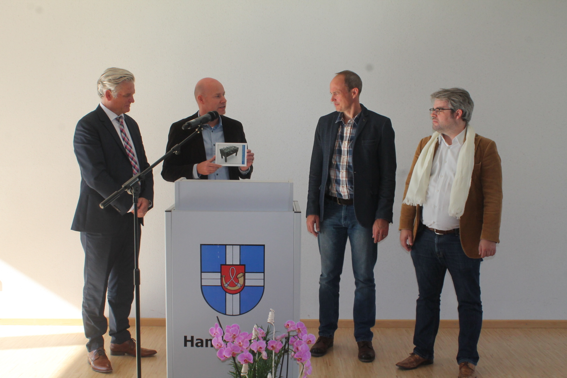 Alexander Weindel (2.v.l.) vom verantwortlichen Planungsbüro überraschte Bürgermeister Thomas Ackermann, Andreas Bensching, Rektor der Pfarrer Graf-Schule, und Stephan Walter, Rektor der Gemeinschaftsschule, (v.l.) mit einem Tischfußballspiel für die frisch sanierte Schule.
