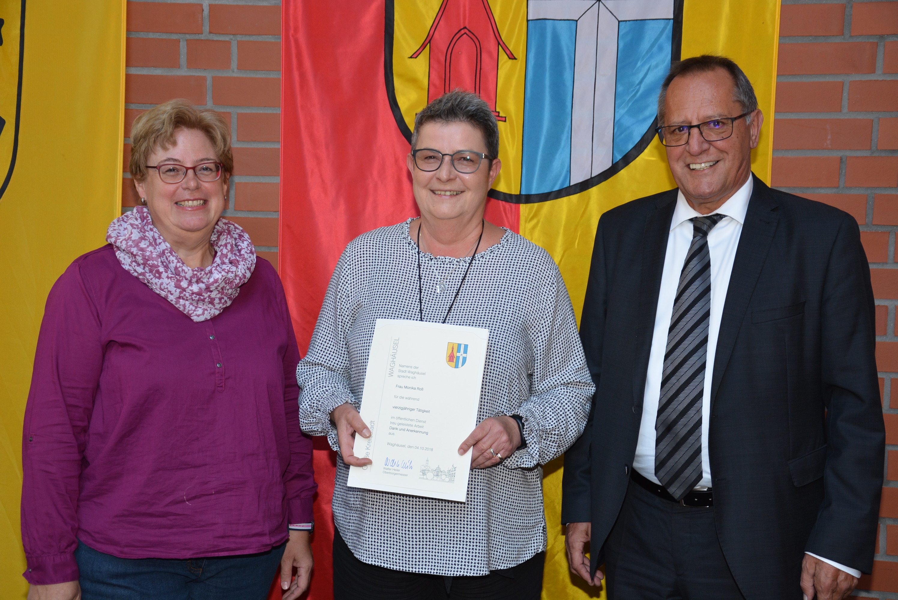 Oberbürgermeister Walter Heiler und Tatjana Dreiforth (Mitglied des Personalrats) gratulieren Monika Roß (Bildmitte) zum Jubiläum.