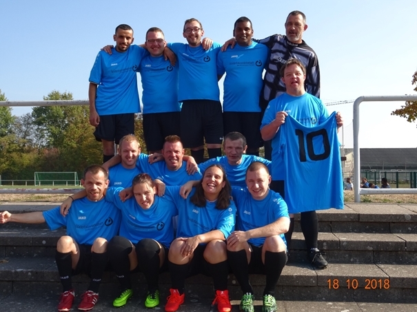 Michael Kögel mit dem Trikot Nr. 10 und seinem Team der Südpfalzwerkstatt .