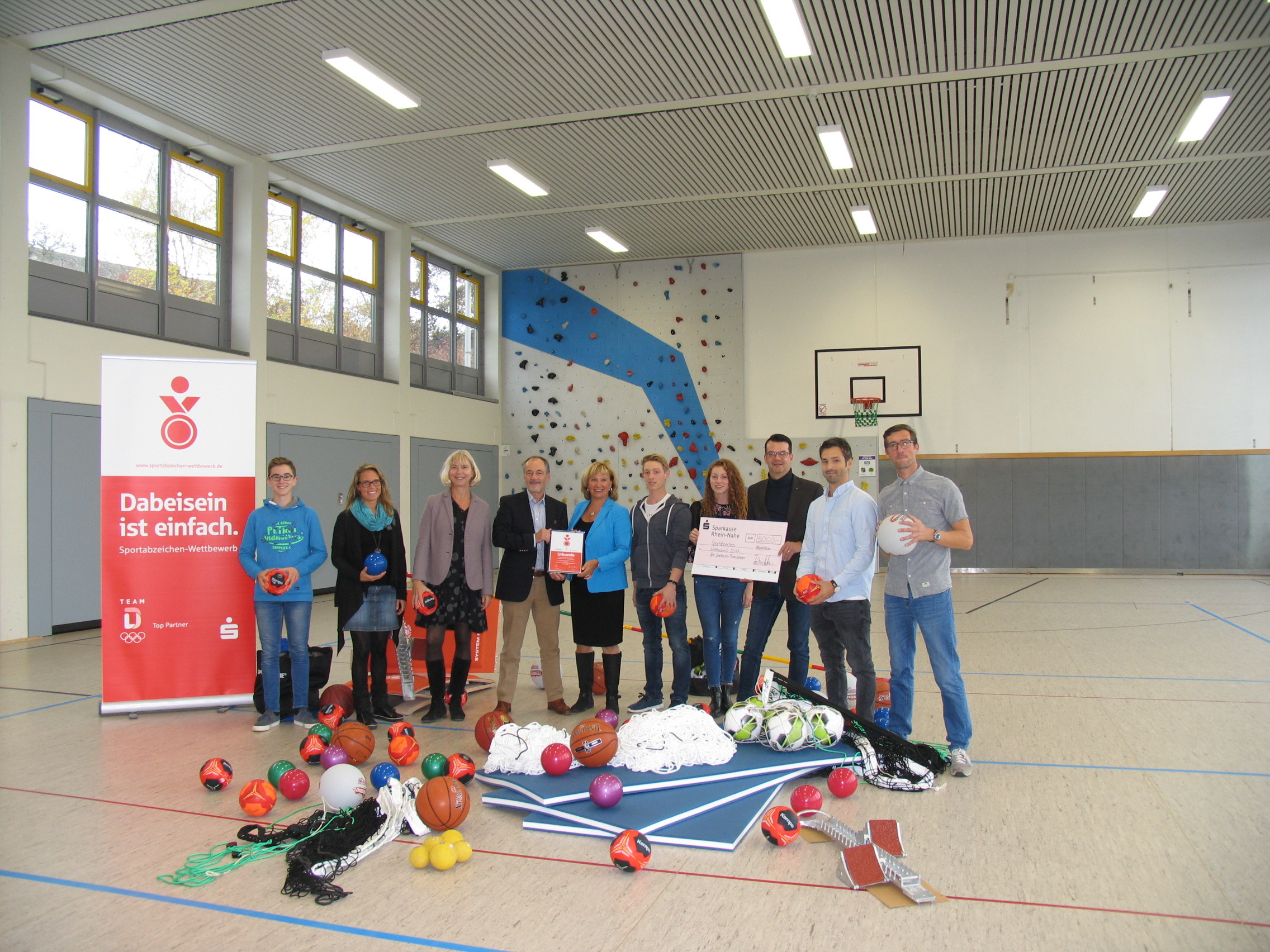 Mit 5000 Euro wurde das sportliche Engagement am PSG geehrt- Unser Bild zeigt: Andreas Peters (4. v.l.) und Jürgen Sauerwein (8.vl.) von der Sparkasse Rhein-Nahe mit Karin Hofmann (5.v.l.) und Jutta Lißmann (3.v.l.) sowie die Sportlehrer Kathrin Sander, Julian Grasser, Felix Fey und die Schüler Maximilian Wahl, Christian Zweigert und Juliane Fuchs. Foto: ps