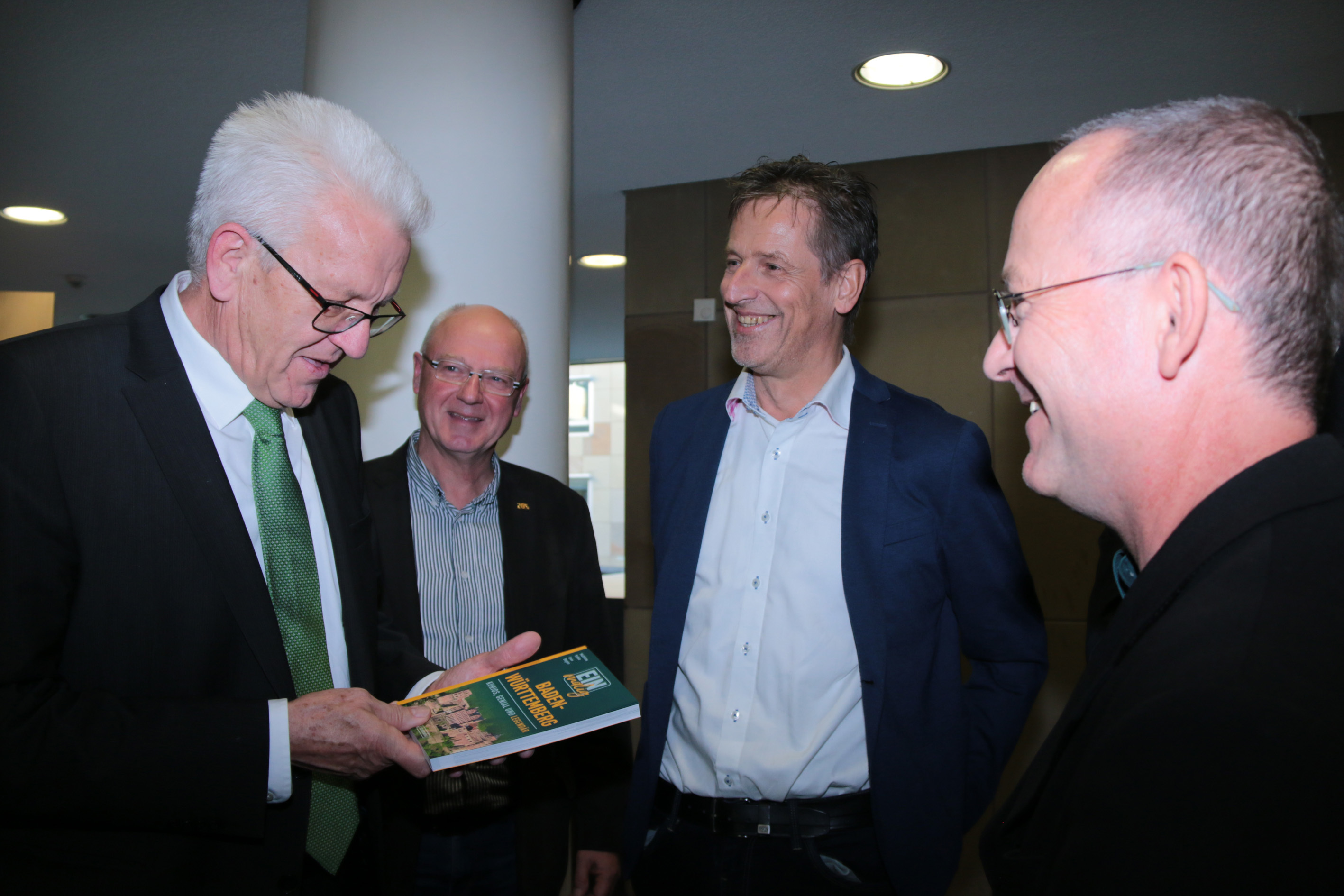 Freut sich über den Band „Einmalig Baden-Württemberg“: Winfried Kretschmann mit Manfred Kern, Uwe Bogen und Matthias Kehle