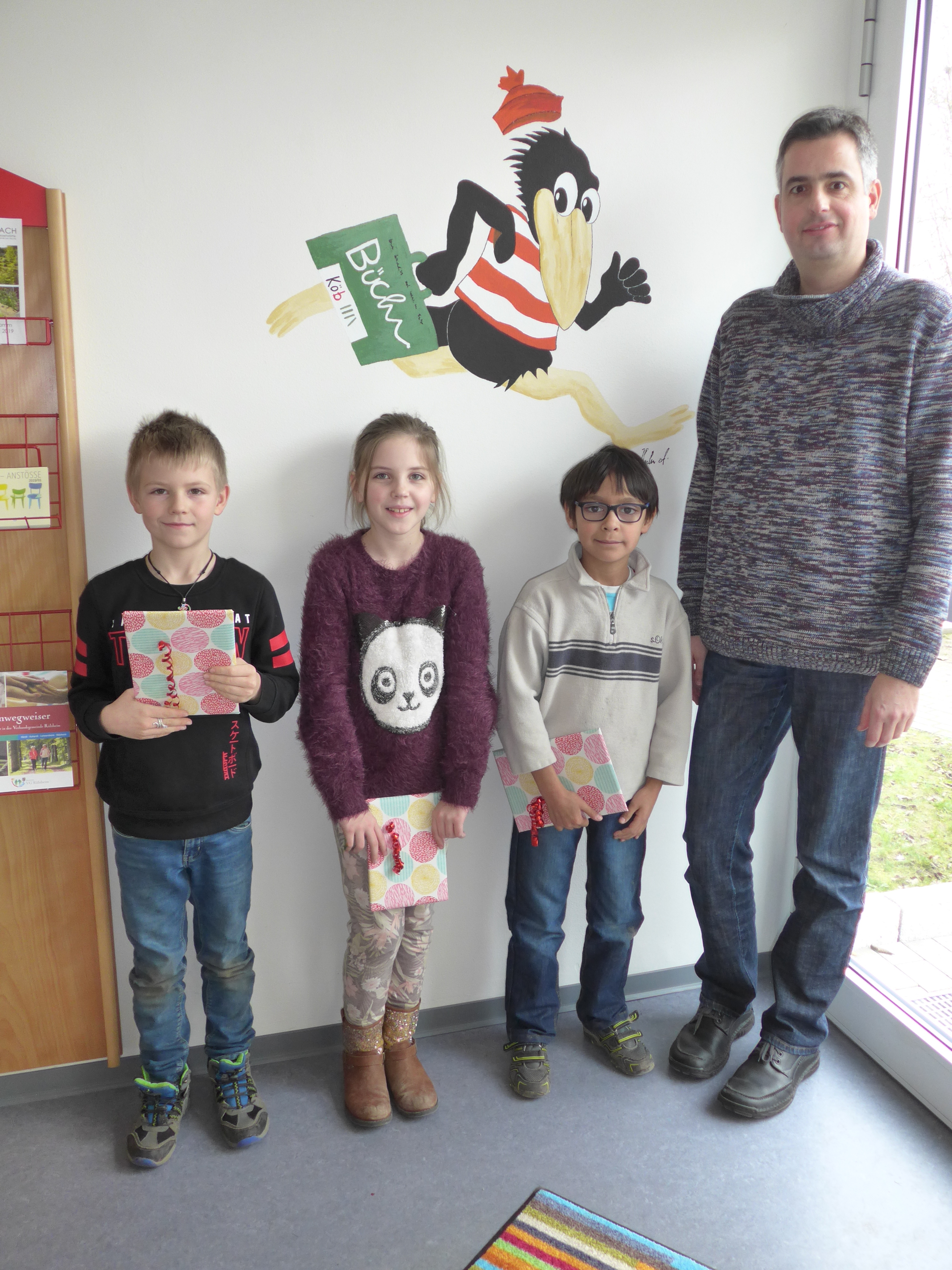 Unser Bild zeigt die stolzen Gewinner: Nicklas (Klasse 2), Milena (Klasse 4) und Leon (Klasse 3) mit Büchereileiter Ulf Weber.