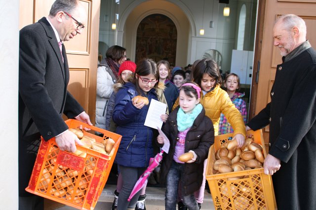 Nach dem Gottesdienst werden die „Veltenswecke“ an die Schulkinder verteilt.