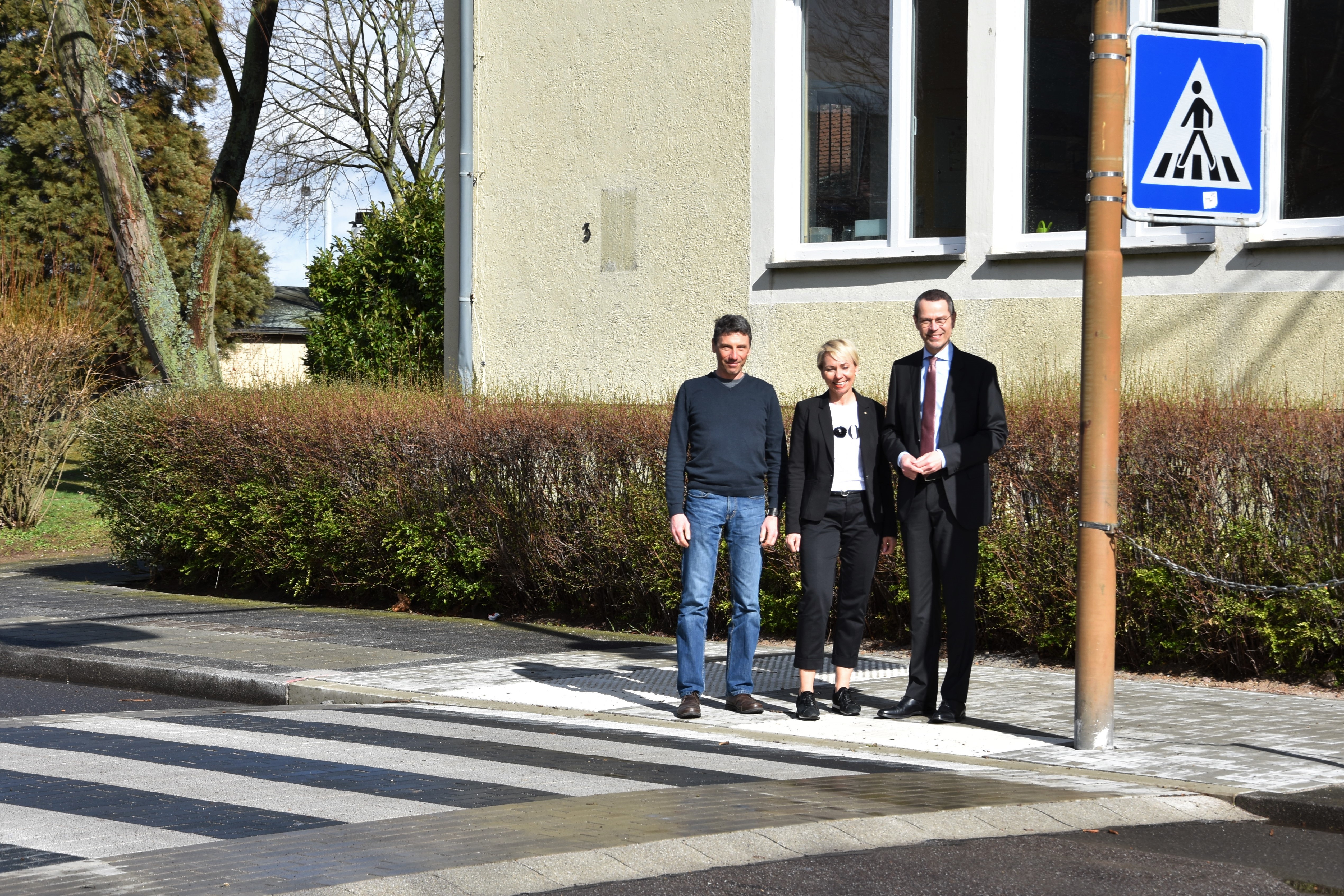 Für mehr Sicherheit auf dem Schulweg: Ralf Bernhard, Leiter der Abteilung Mobilität und Verkehrsinfrastruktur beim städtischen Bauamt, Schulleiterin Pascale Schneider und Bürgermeister Dr. Maximilian Ingenthron (v.l.n.r.) an der aufgepflasterten Fußgängerüberquerung vor der Landauer Thomas-Nast-Grundschule.