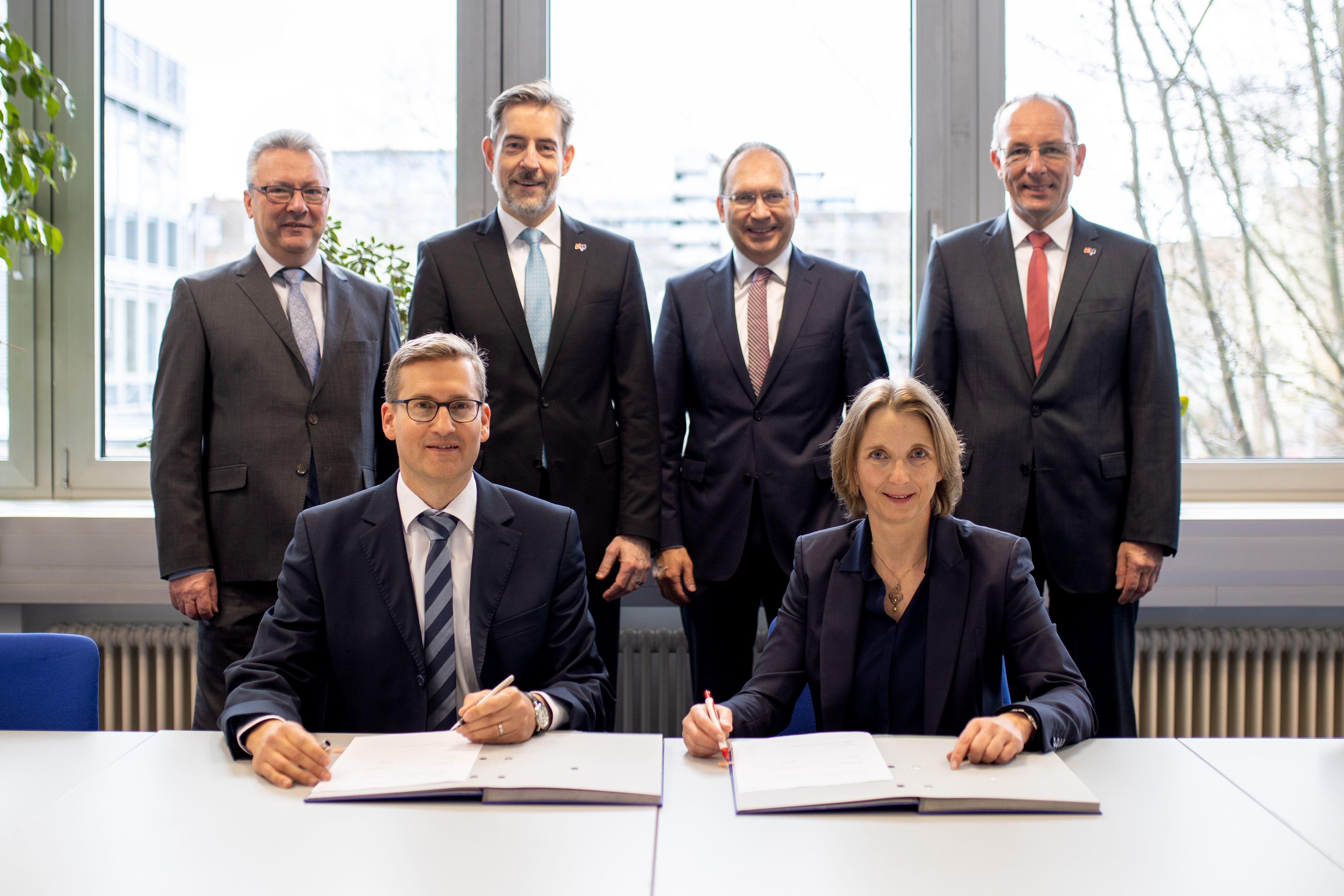 Vertragsunterzeichnung mit: Markus Morlock, Stadtwerke Heidelberg Netze, und Eva Werner, MVV Energie, die beiden Geschäftsführer der neuen Gesellschaft wärme.netz.werk; stehend: Peter Erb, Prokurist bei den Stadtwerken Heidelberg Energie, Dr. Hansjörg Roll, Technikvorstand der MVV Energie, Michael Teigeler, Geschäftsführer der Stadtwerke Heidelberg Energie, sowie Ralf Klöpfer, Vertriebsvorstand der MVV Energie.