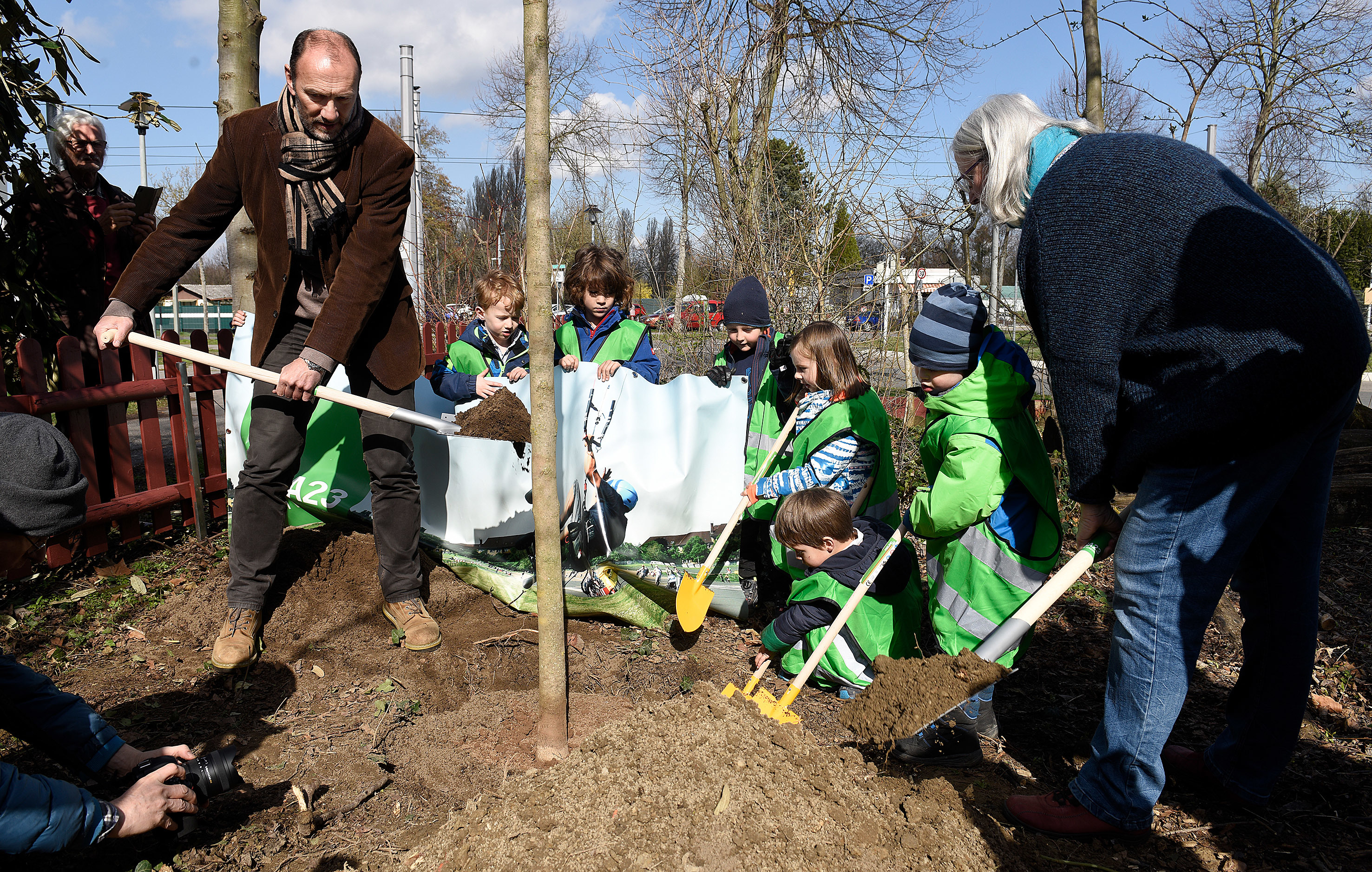 Gemeinsam mit Vereinsgeschäftsführerin Martina Haaf (rechts) und Mannheims BUGA-Chef Michael Schnellbach (links) haben die Kinder den Baum in die Erde gesetzt