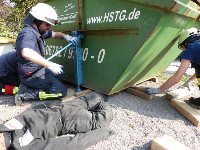 Befreiung einer eingeklemmten Person (Dummy) mit Büffelheber unter einem Muldencontainer