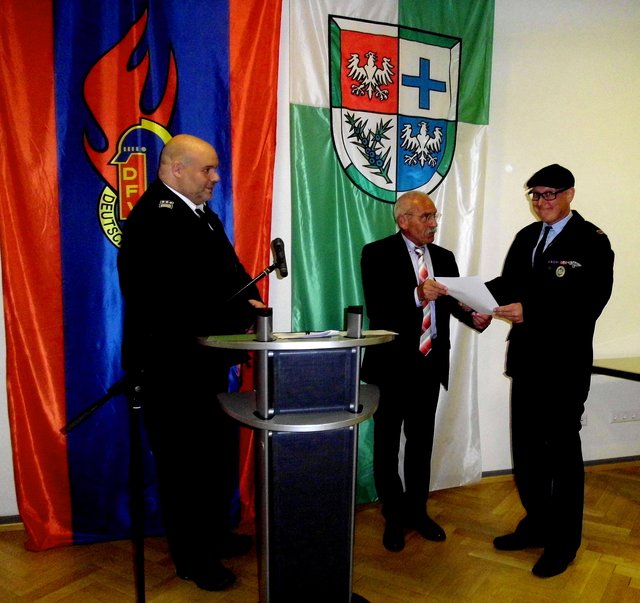 Dennis Zick (Hinterweidenthal) erhält seine Beförderung zum Hauptbrandmeister; links: Wehrleiter Johannes Seibel, Mitte Bürgermeister Werner Kölsch | Foto: W. G. Stähle