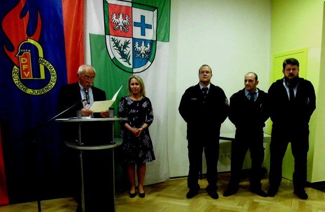 Ehrung für 25 Jahre: Sascha Müller (Hinterweidenthal), Stefan Pecher jun. (Spirkelbach), Andreas Eyer (Wilgartswiesen); links Bürgermeister Kölsch, 2. v. li. Landrätin Dr. Ganster; im Hintergrund Wappen der Dt. Jugendfeuerwehr (li.), Wappen der Verbandsgemeinde | Foto: W. G. Stähle