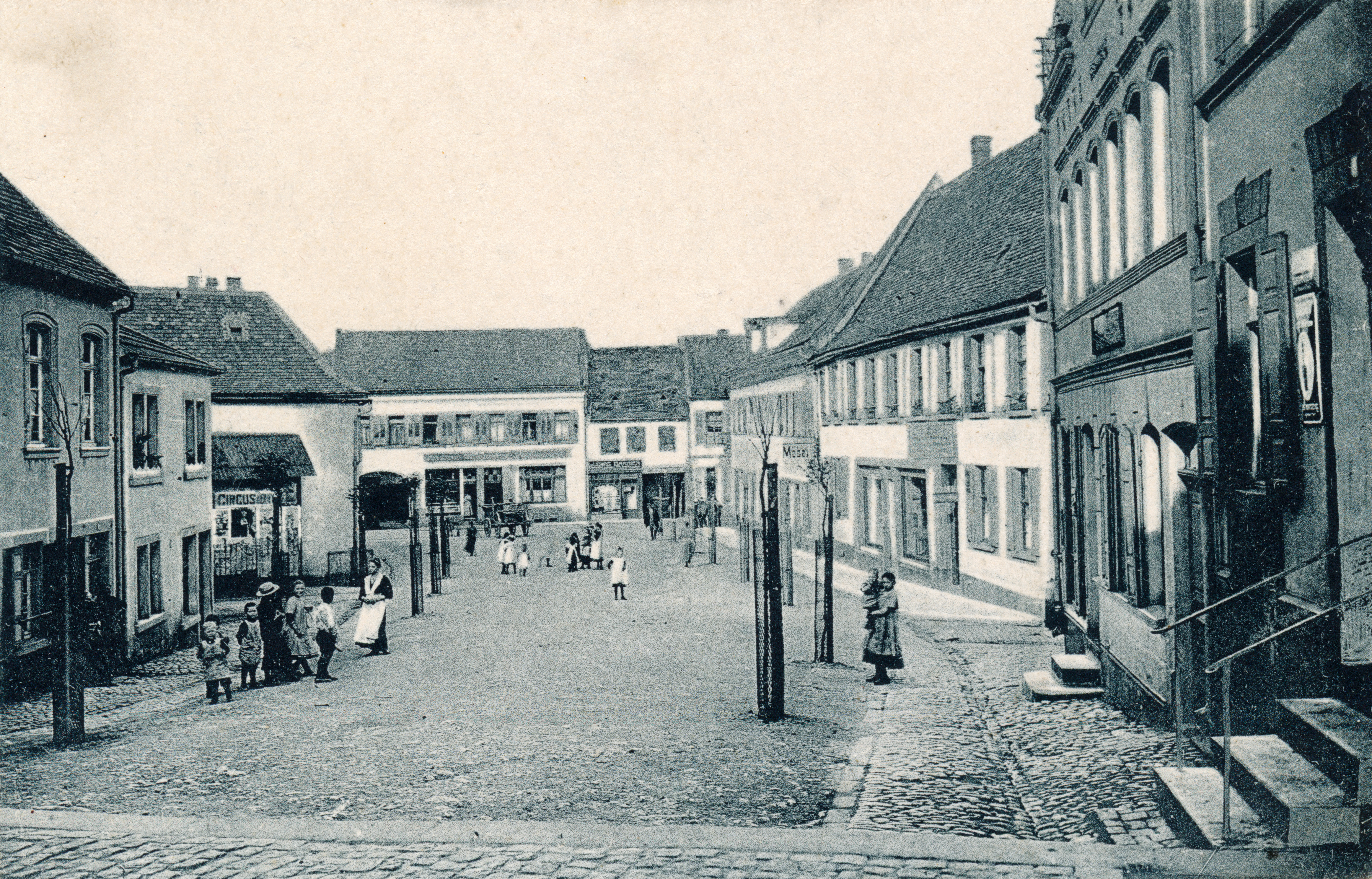 Der Schillerplatz in Grünstadt um 1915. Im Vordergrund rechts ist der Kolonialwarenladen von Anna Mehle.