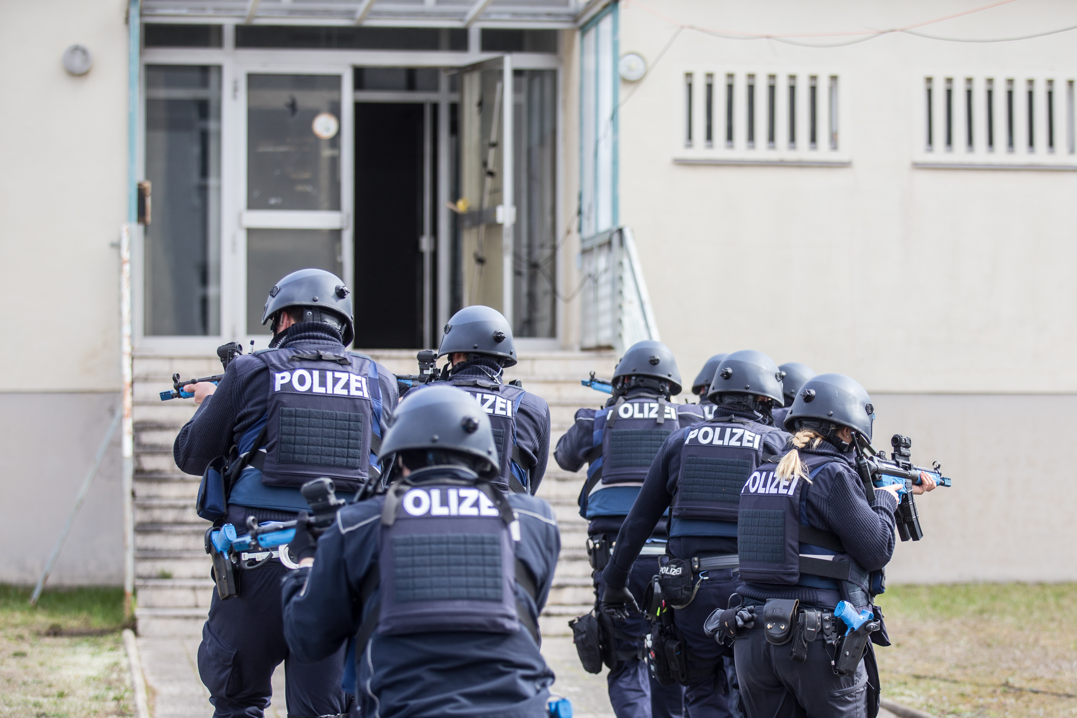 Nach allen Seiten sichern sich die Polizeibeamten beim Sturm des Gebäudes ab.