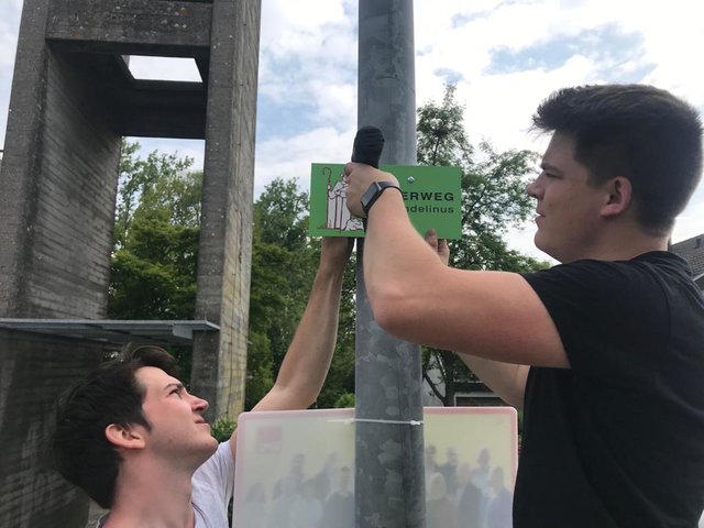 Das Schild für den Pilgerweg wird angebracht  Foto: ps