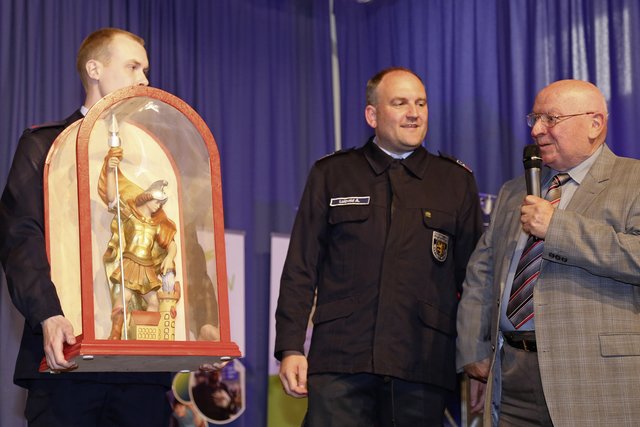 Hobby-Drechsler Hans Herrmann übergibt seinen handgefertigten, hölzernen Heiligen Florian an Pascal Kihl und André Luipold. | Foto: Anke Luipold