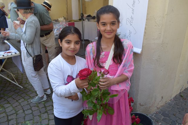 Jede Besucherin erhielt am Eingang zum Schloss-Innenhof zur Begrüßung eine Rose von diesen beiden freundlichen Damen überreicht.  | Foto: B.Bender