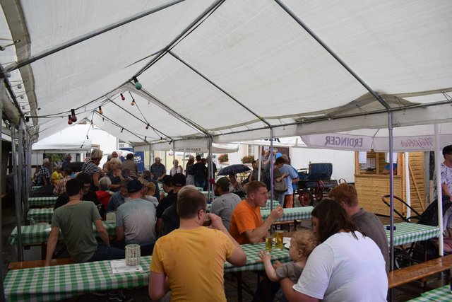 Die zahlreich erschienen Gäste machen es sich bei prasselndem Starkregen im Zelt gemütlich.  | Foto: B.Bender