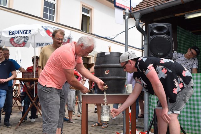 Ozapft 'is. Ortsbürgermeister Felix Schönung hält sich mit Sicherheitsabstand im Hintergrund.  | Foto: B.Bender