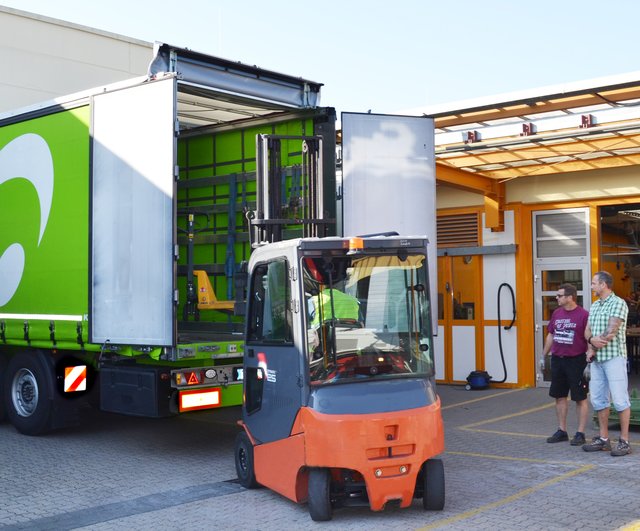 Vorbereitung: Unter den Blicken von Jürgen Dörrzapf (links) und Frank Hinterlang befördert ein Gabelstapler einen Hubwagen in den 40-Tonner. Bevor die Schlagschere herausgehoben werden kann, müssen die Kleinteile weichen.  | Foto: Christmann/Lebenshilfe Südliche Weinstraße
