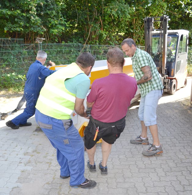 Mit vereinten Kräften: Auf den letzten Metern sind sieben Helfer, ein Hubwagen und ein Gabelstapler im Einsatz.	 | Foto: Christmann/Lebenshilfe Südliche Weinstraße