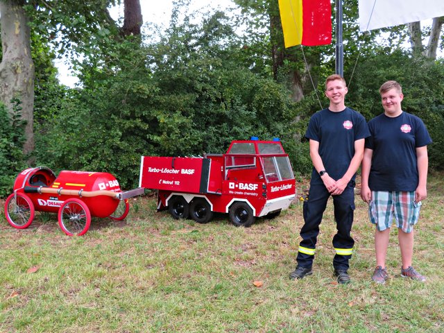 Aktive Feuerwehr-Mitglieder Nik Schlee und Dustin Höhnle neben den BASF-Modellen | Foto: Brigitte Melder