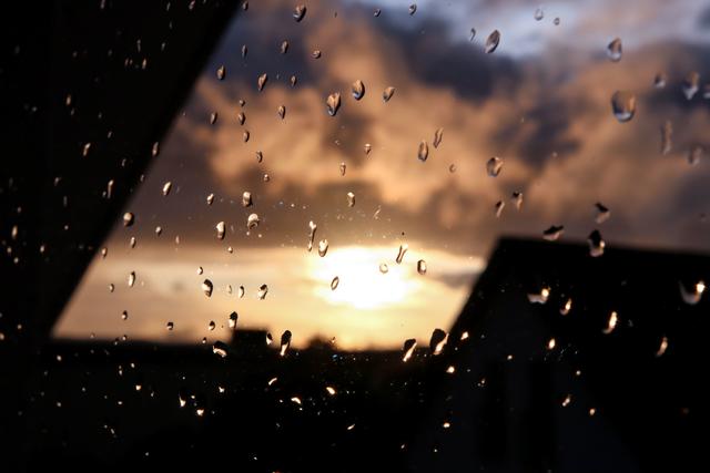 Regentropfen an einer Fensterscheibe mit Sonnenuntergang, Regulshausen