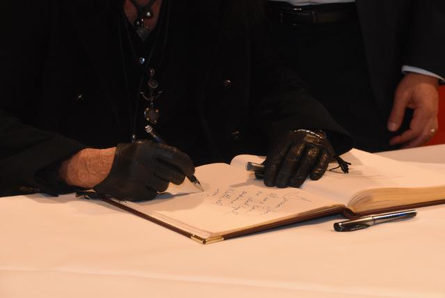 In typischer Kleidung und Outfit trägt sich der US-Rockmusiker Alice Cooper in das Goldene Buch Baden-Badens ein. Rechts Bürgermeister Roland Kaiser.  | Foto: Roland Seiter