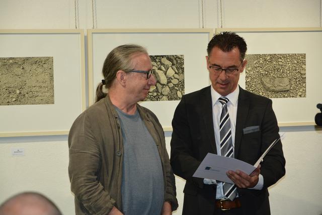 Preisträger Michael Rausch bei der Übergabe des Kunstpreises durch Herrn Christoph Buttweiler, Erster Kreisbeigeordneter. Im Hintergrund drei seiner Werke, die noch bis 6.10. im Zehnthaus Jockgrim zu sehen sind.  | Foto: A. Abt